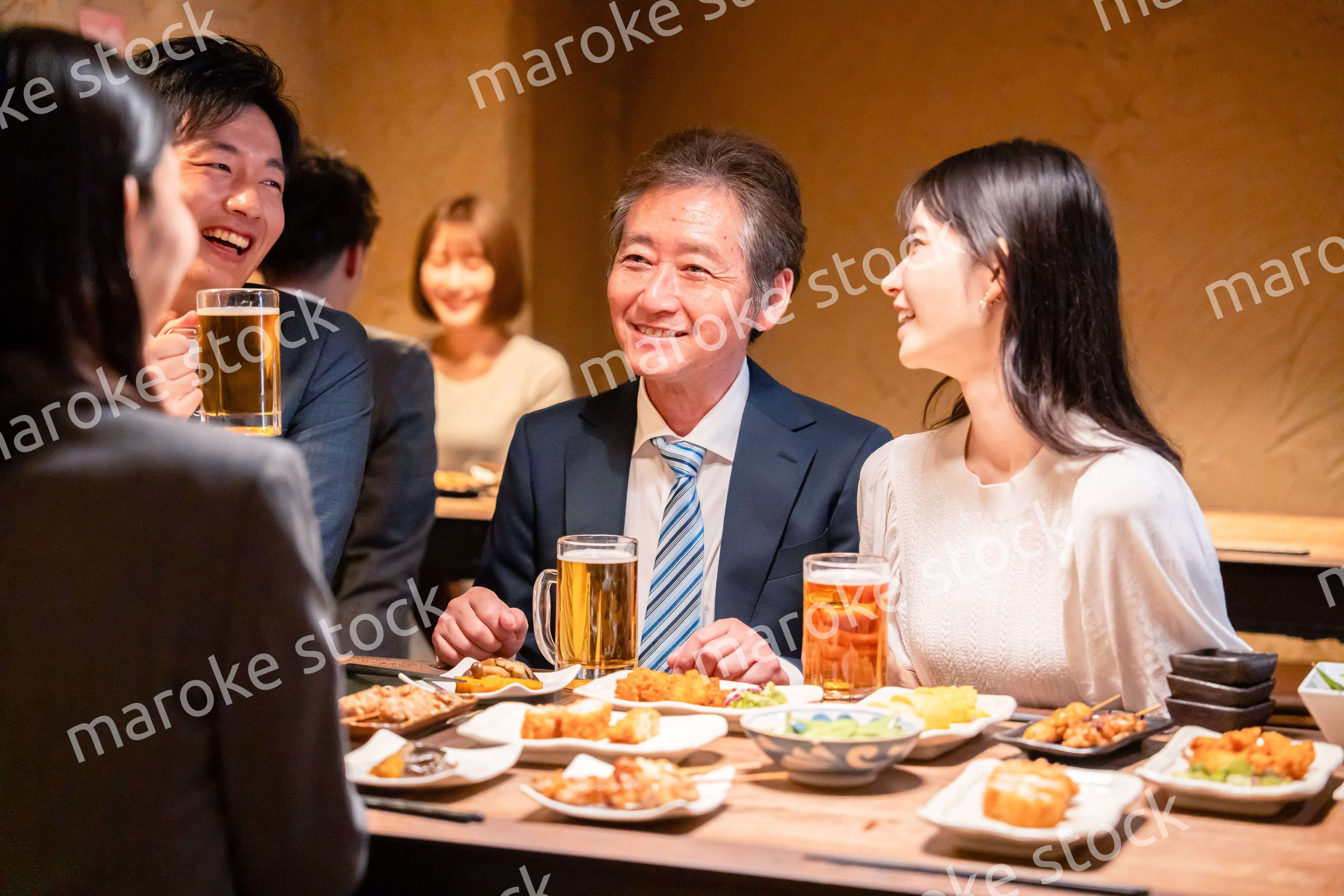 居酒屋で部署のお疲れ様会をするビジネスパーソン