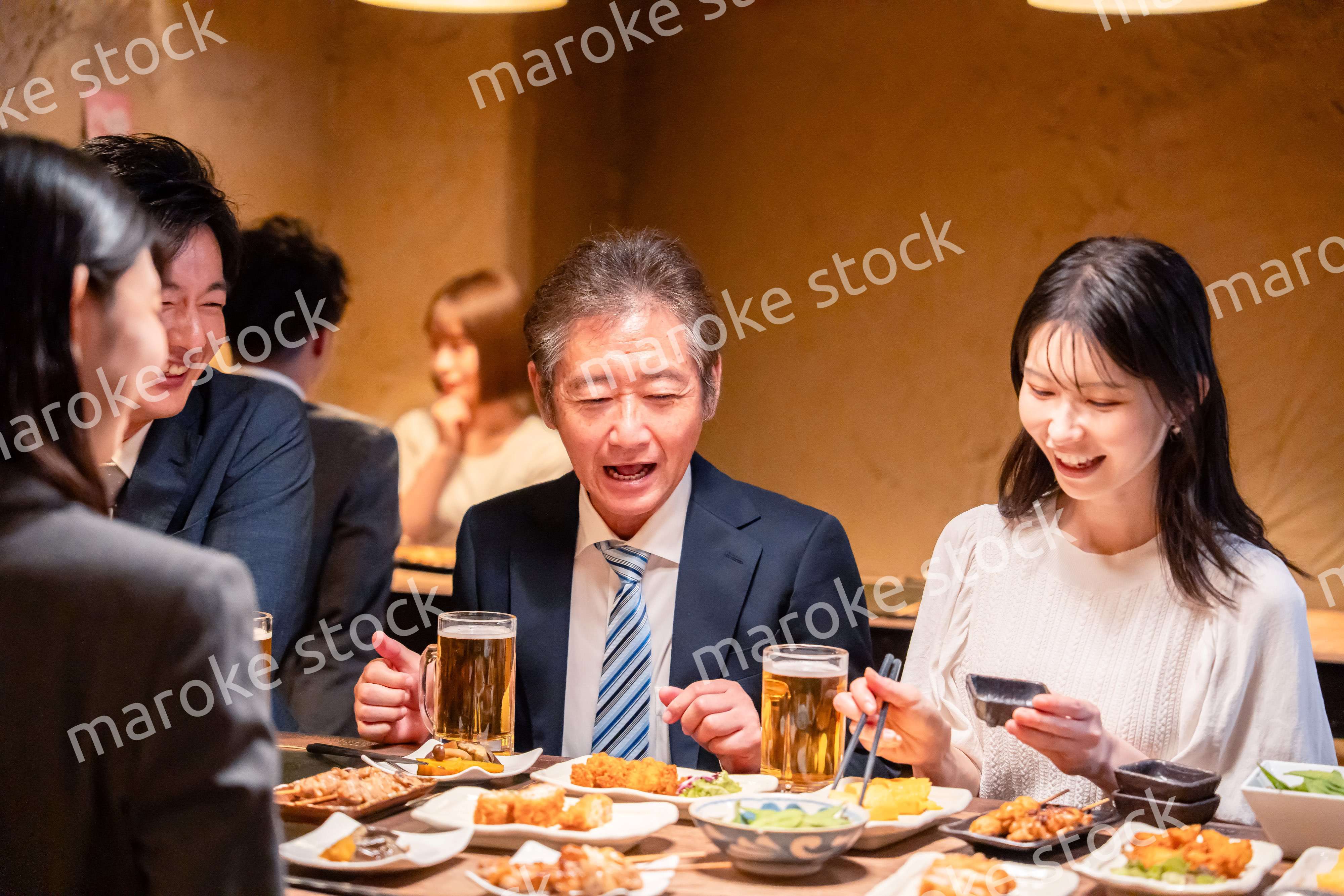 居酒屋で部署のお疲れ様会をするビジネスパーソン