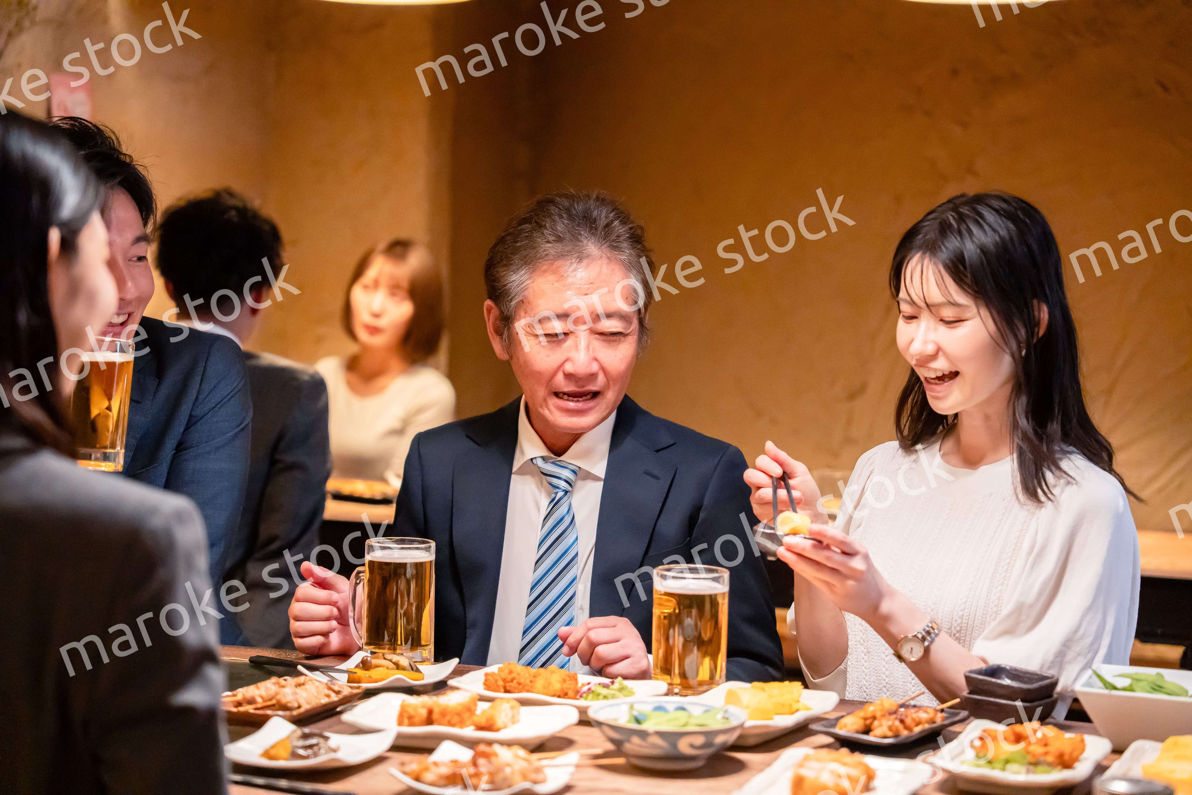 居酒屋で部署のお疲れ様会をするビジネスパーソン