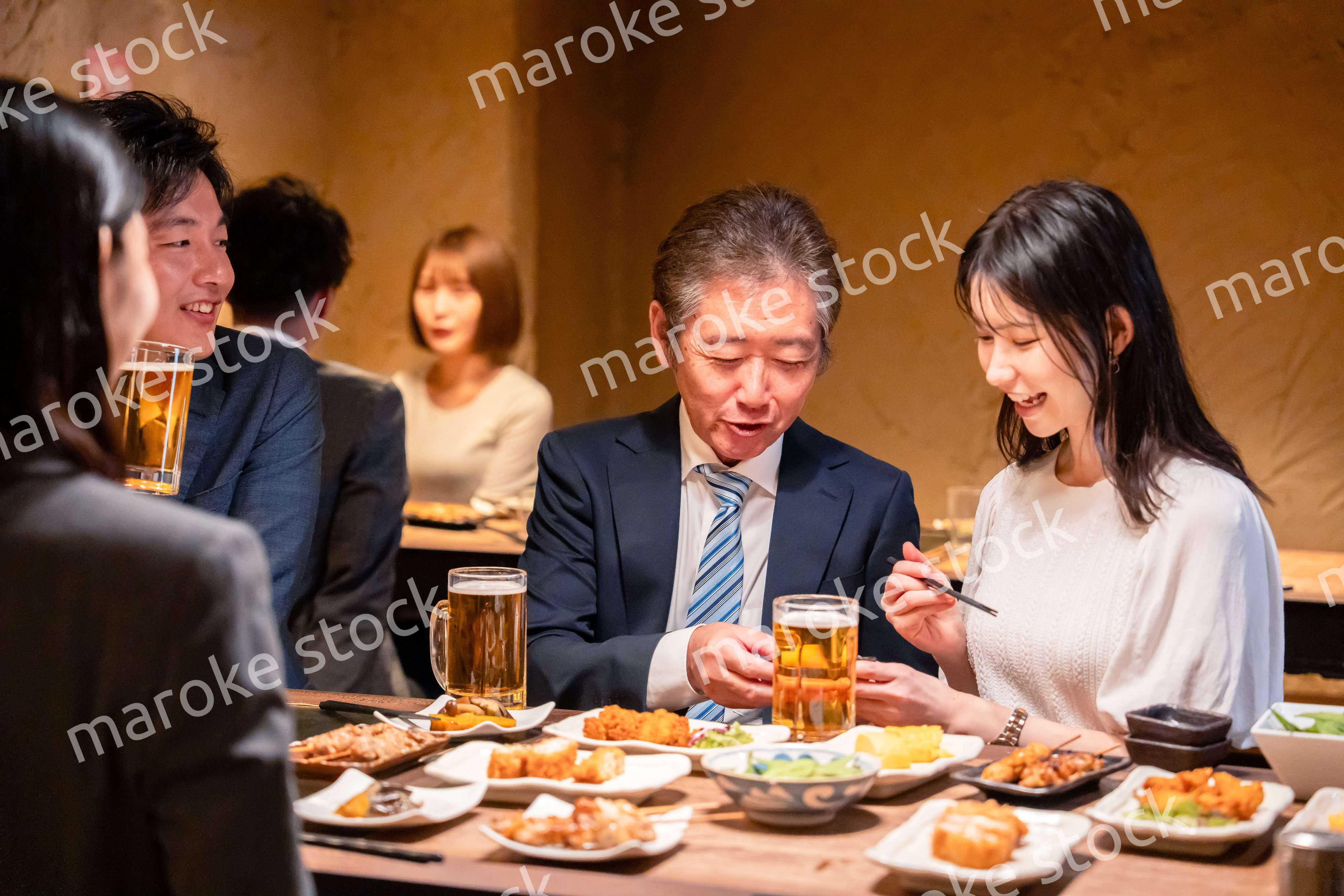 居酒屋で部署のお疲れ様会をするビジネスパーソン