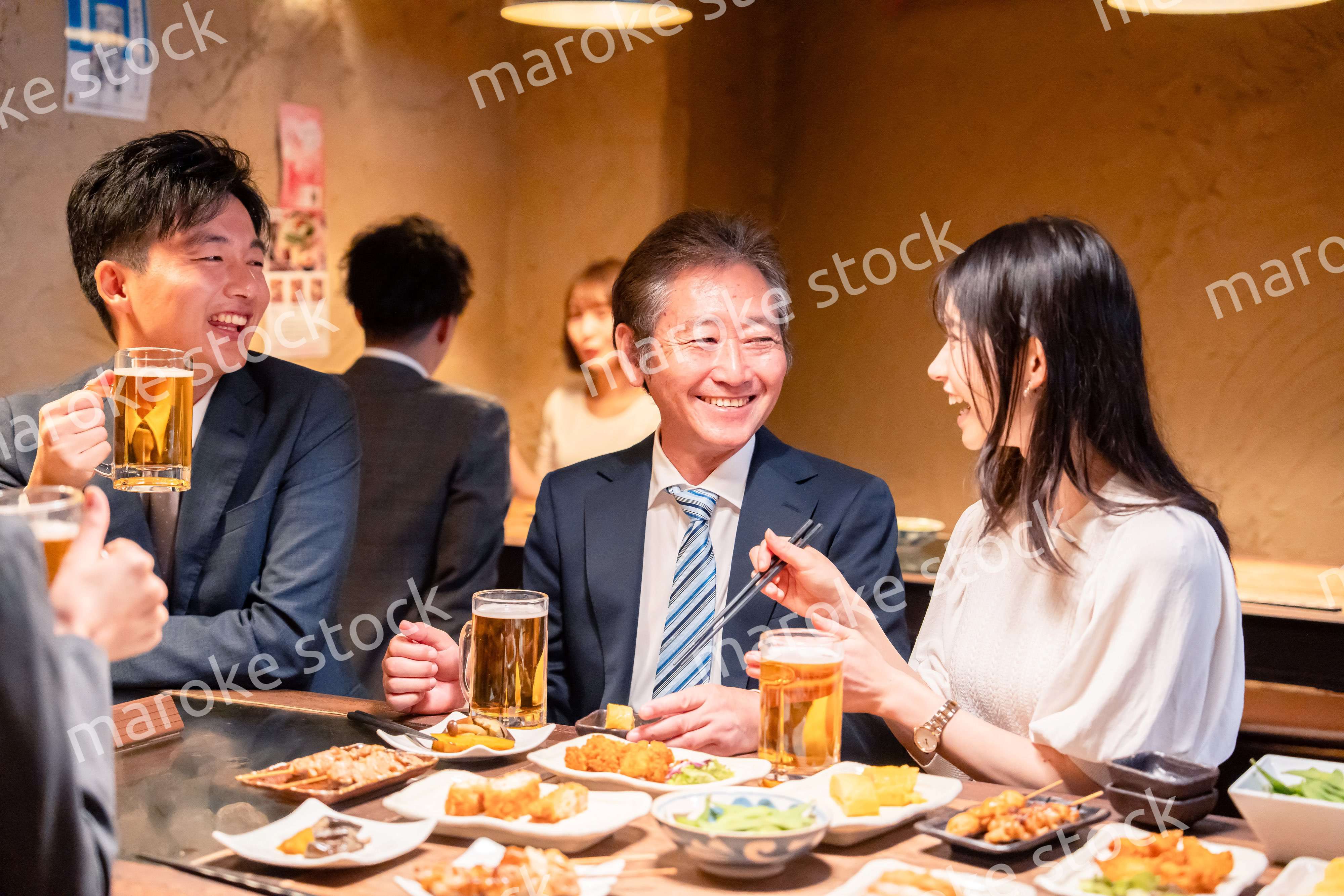 居酒屋で部署のお疲れ様会をするビジネスパーソン