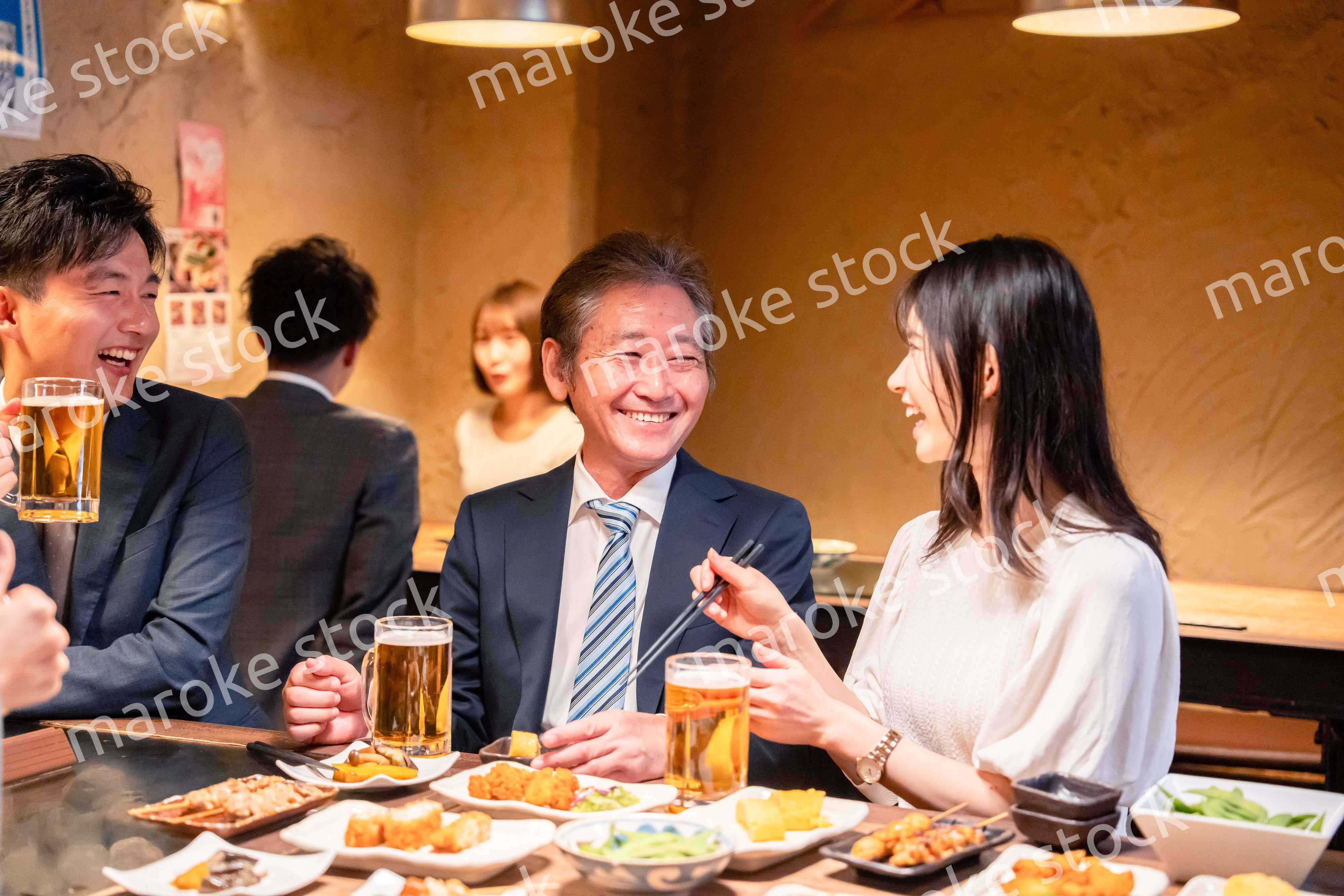 居酒屋で部署のお疲れ様会をするビジネスパーソン