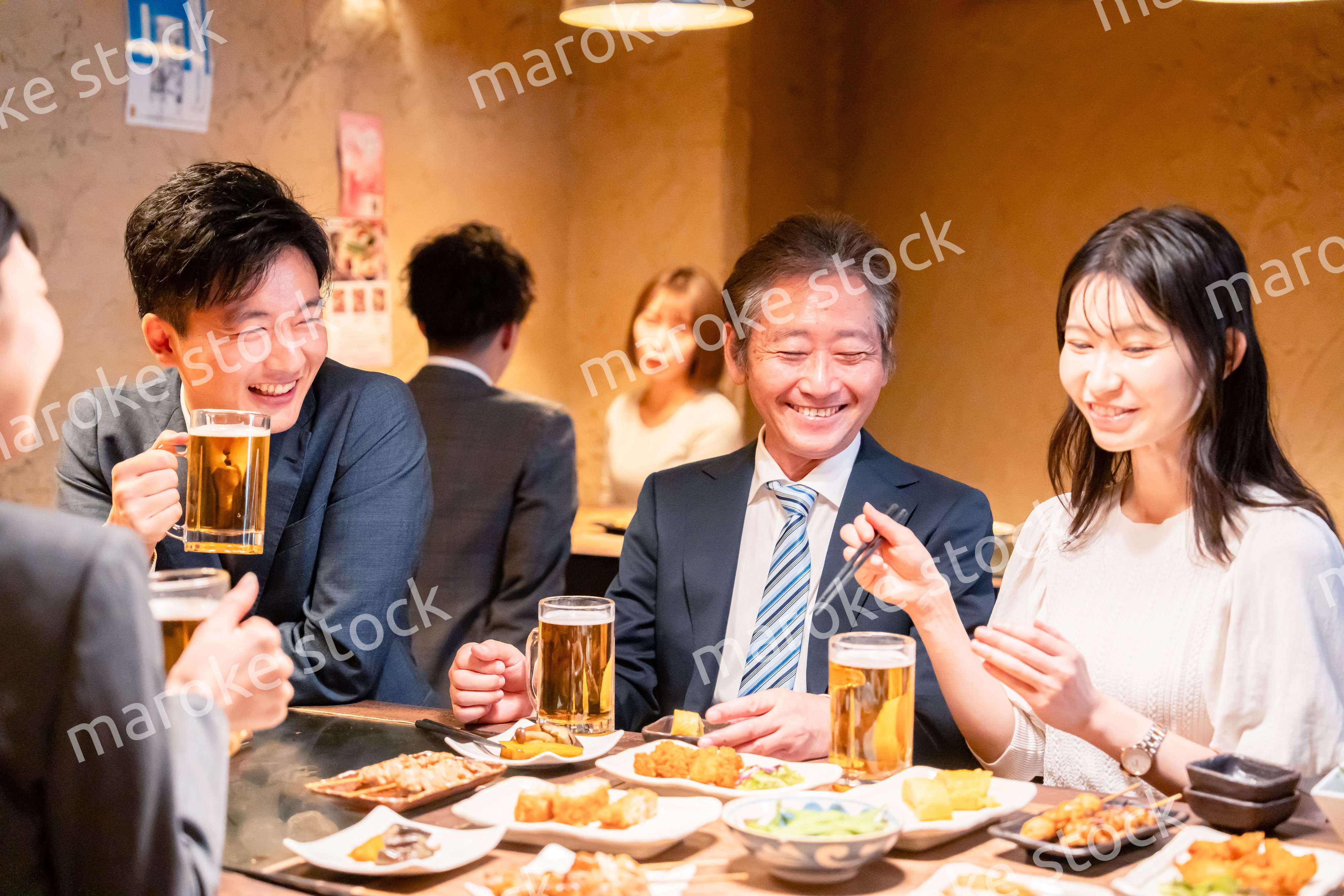 居酒屋で部署のお疲れ様会をするビジネスパーソン