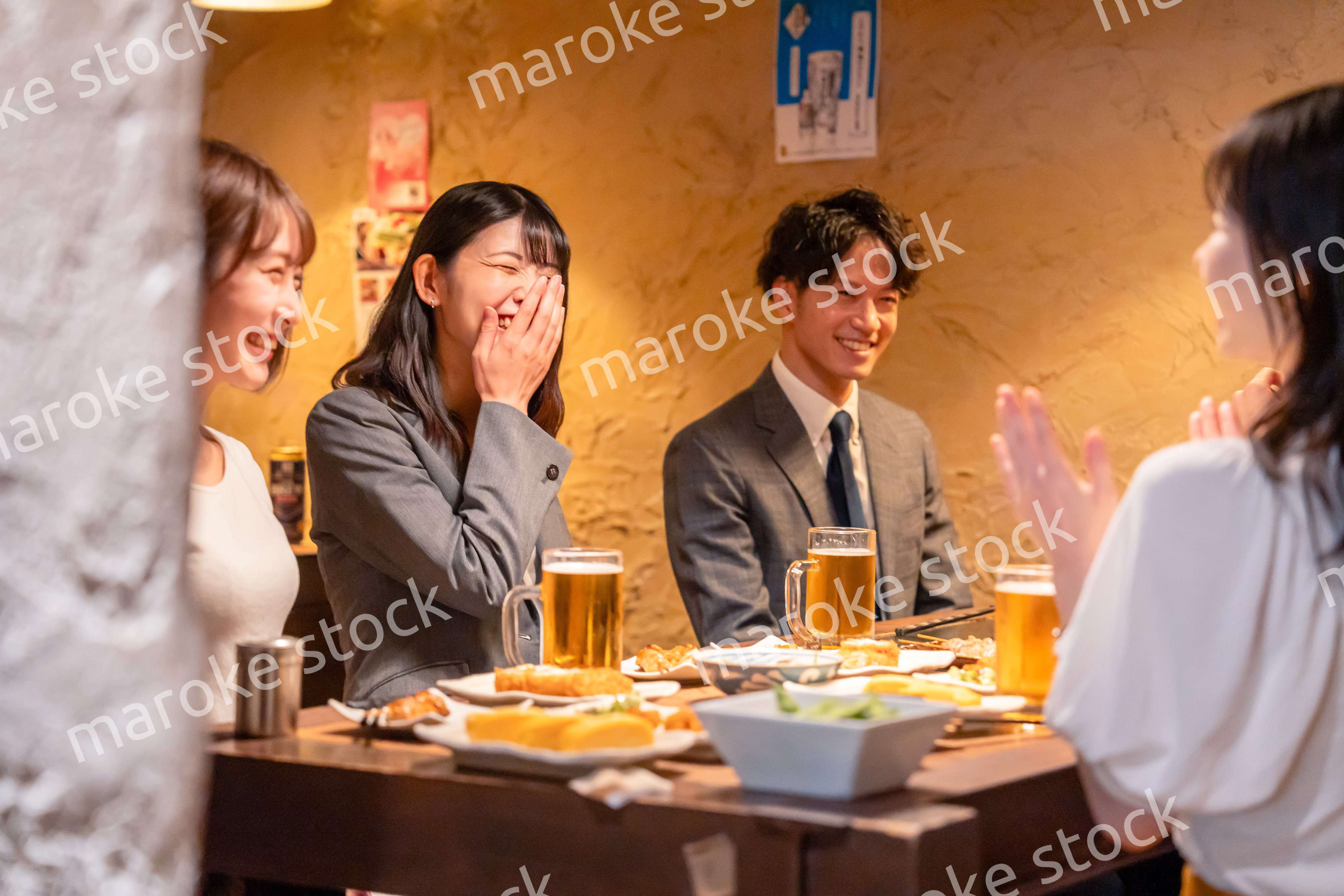 飲み会で大爆笑して盛り上がる会社員の女性