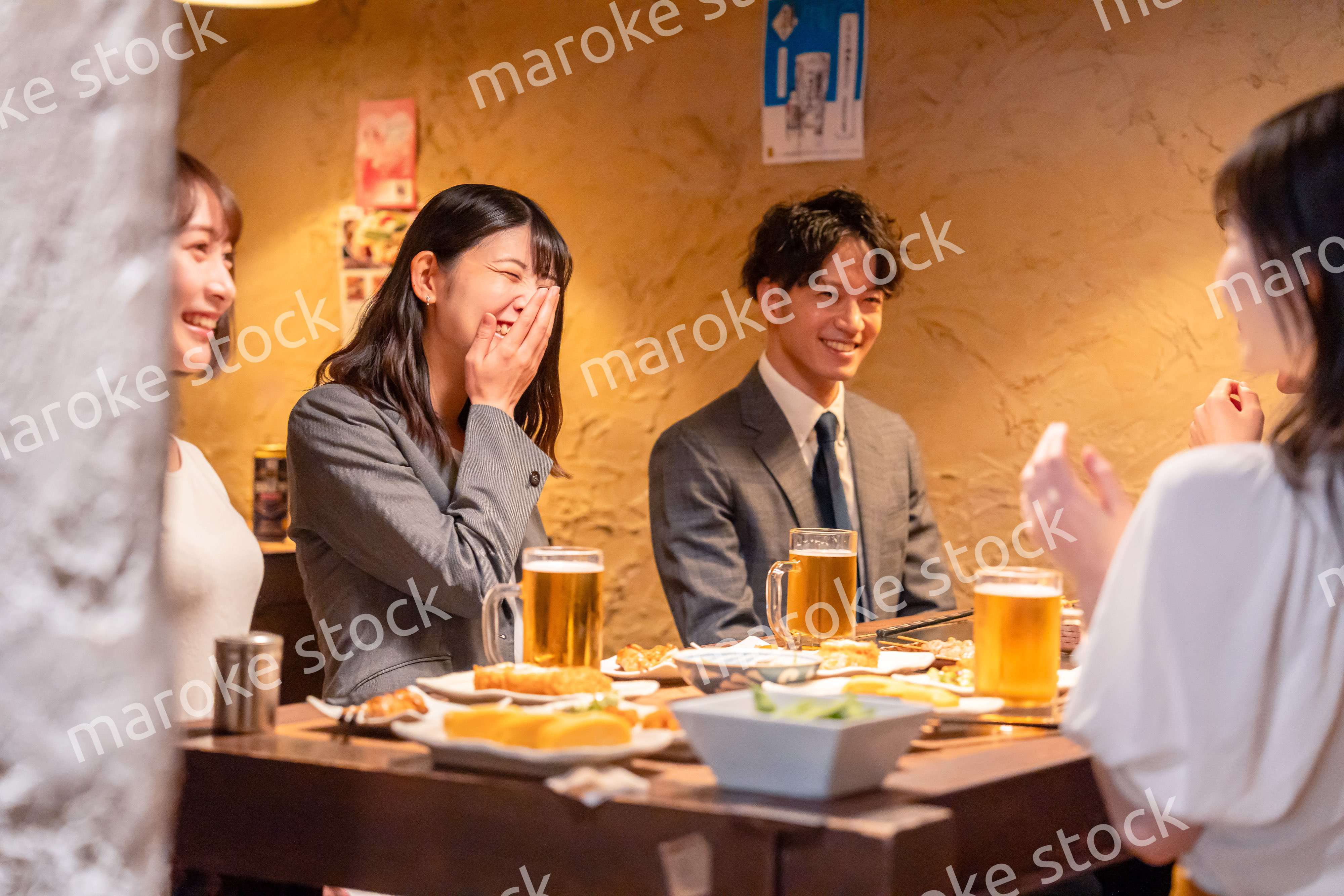 飲み会で大爆笑して盛り上がる会社員の女性