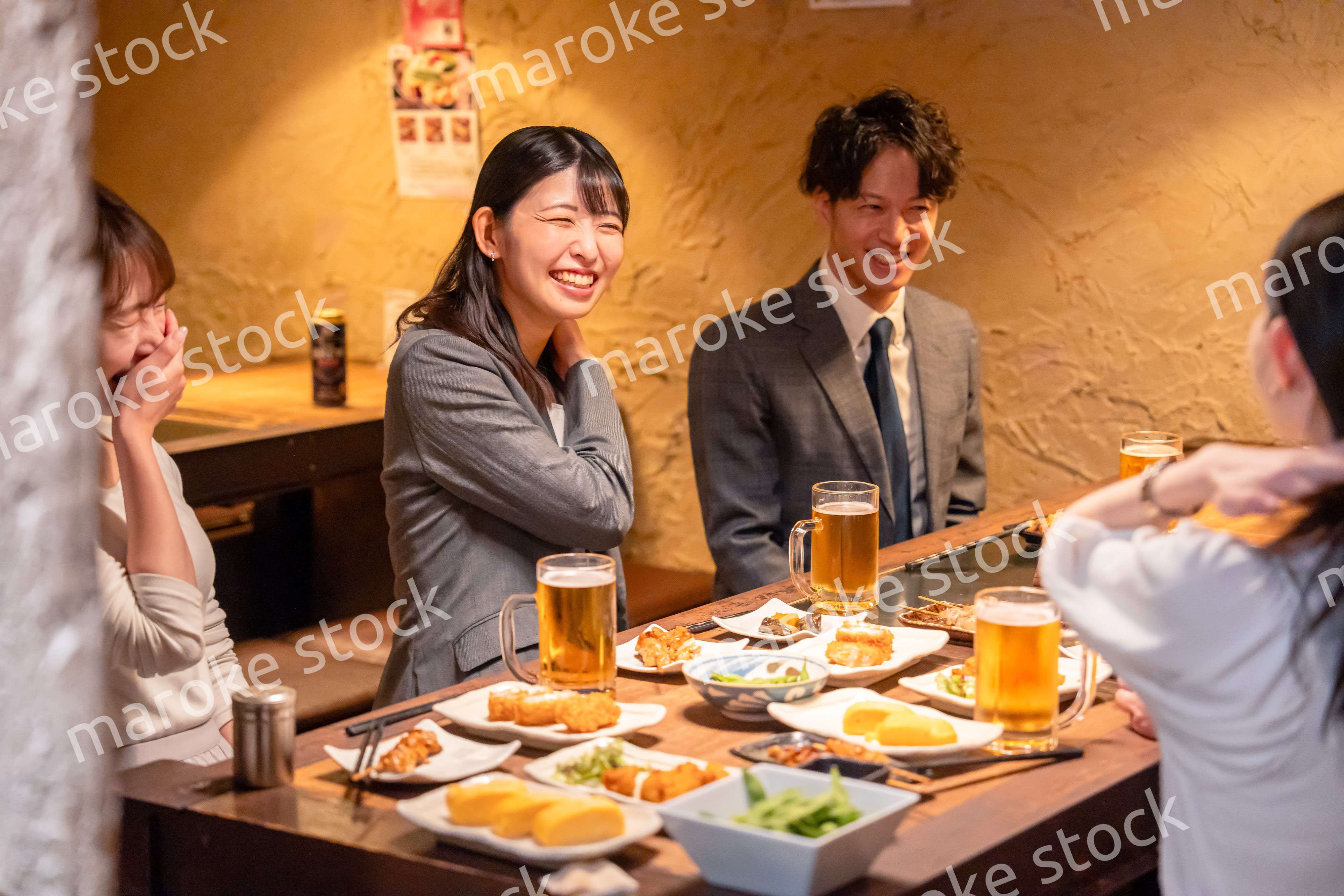 飲み会で大爆笑して盛り上がる会社員の女性