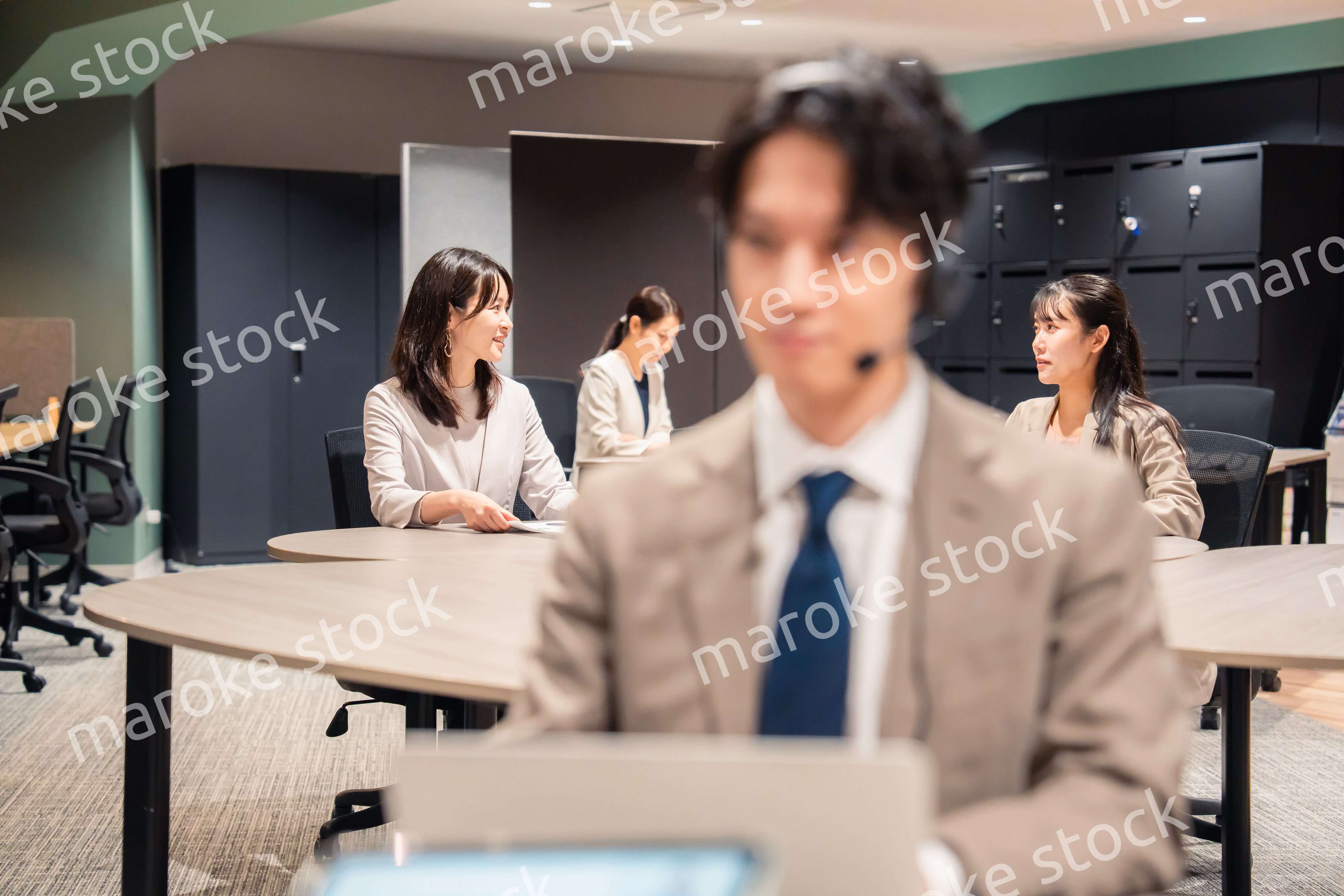 オフィスで楽しく話しながら働く女性