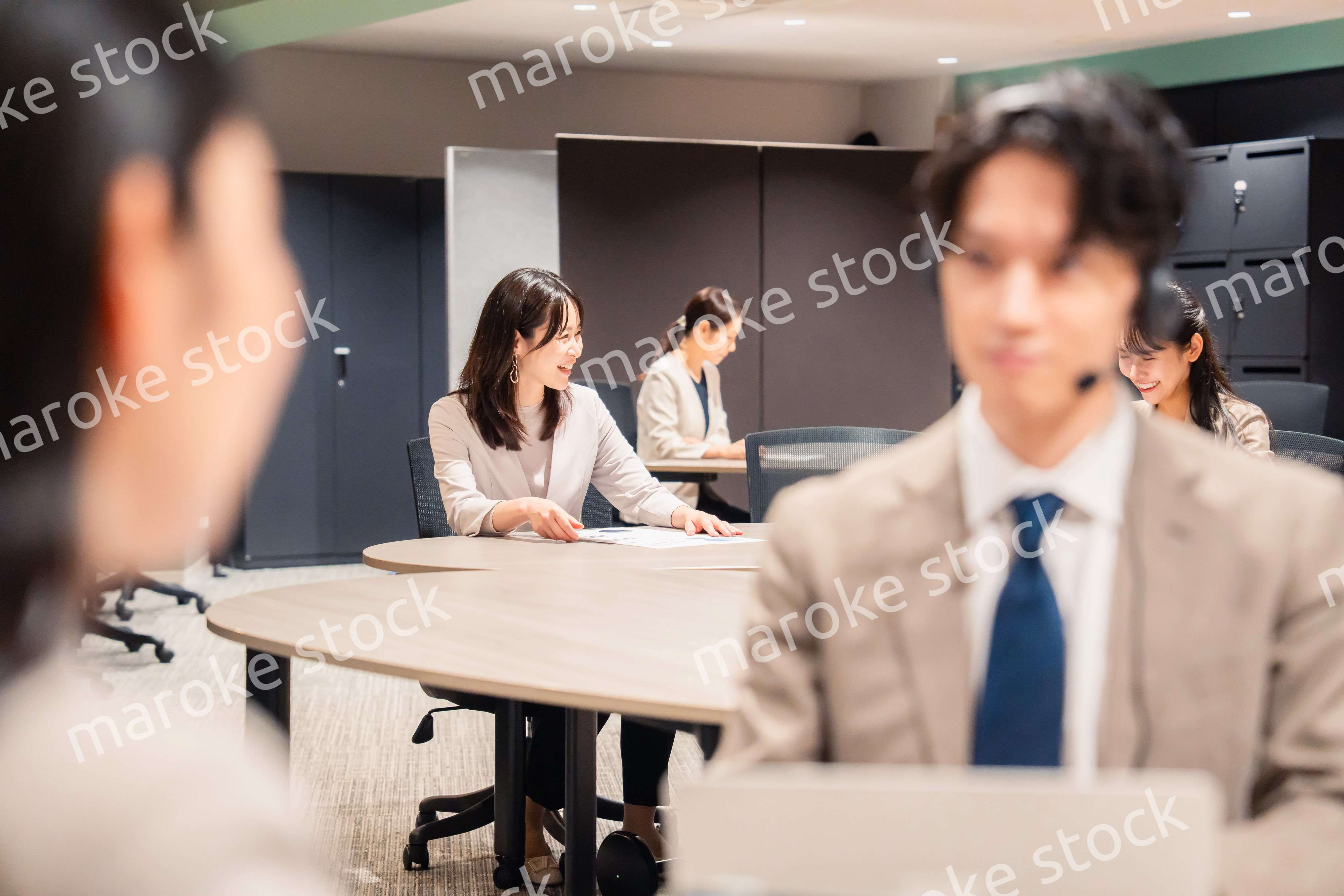 オフィスで楽しく話しながら働く女性