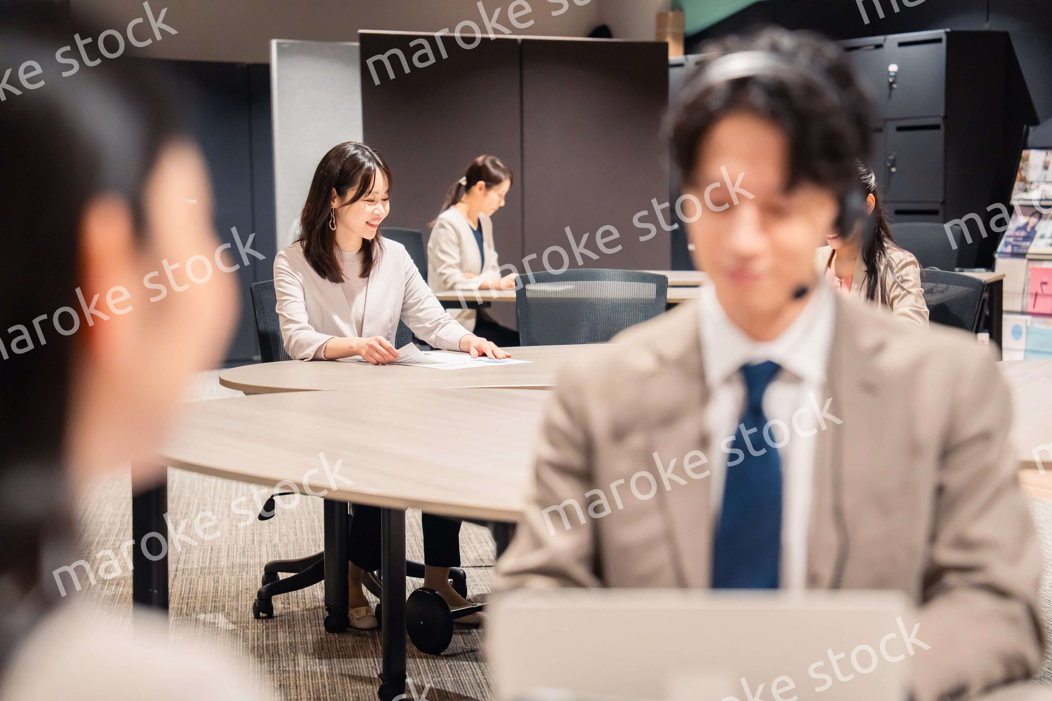 オフィスで楽しく話しながら働く女性