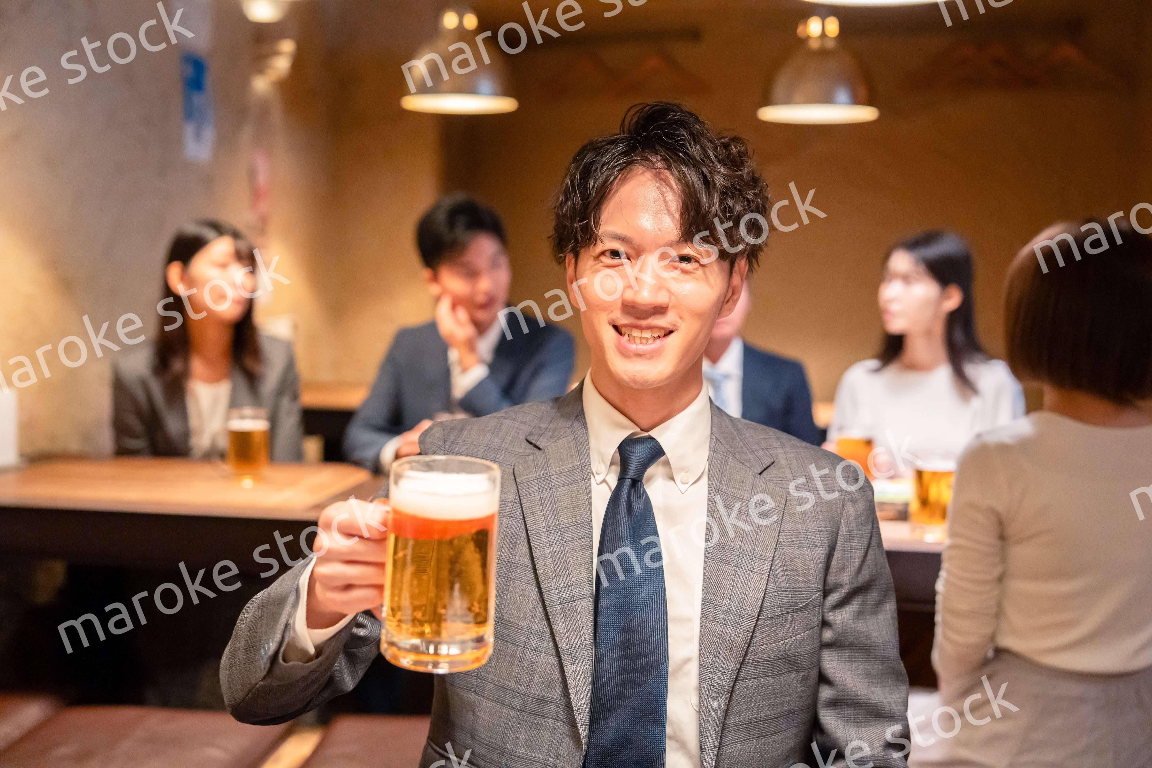 居酒屋でビールの乾杯をするサラリーマンの男性