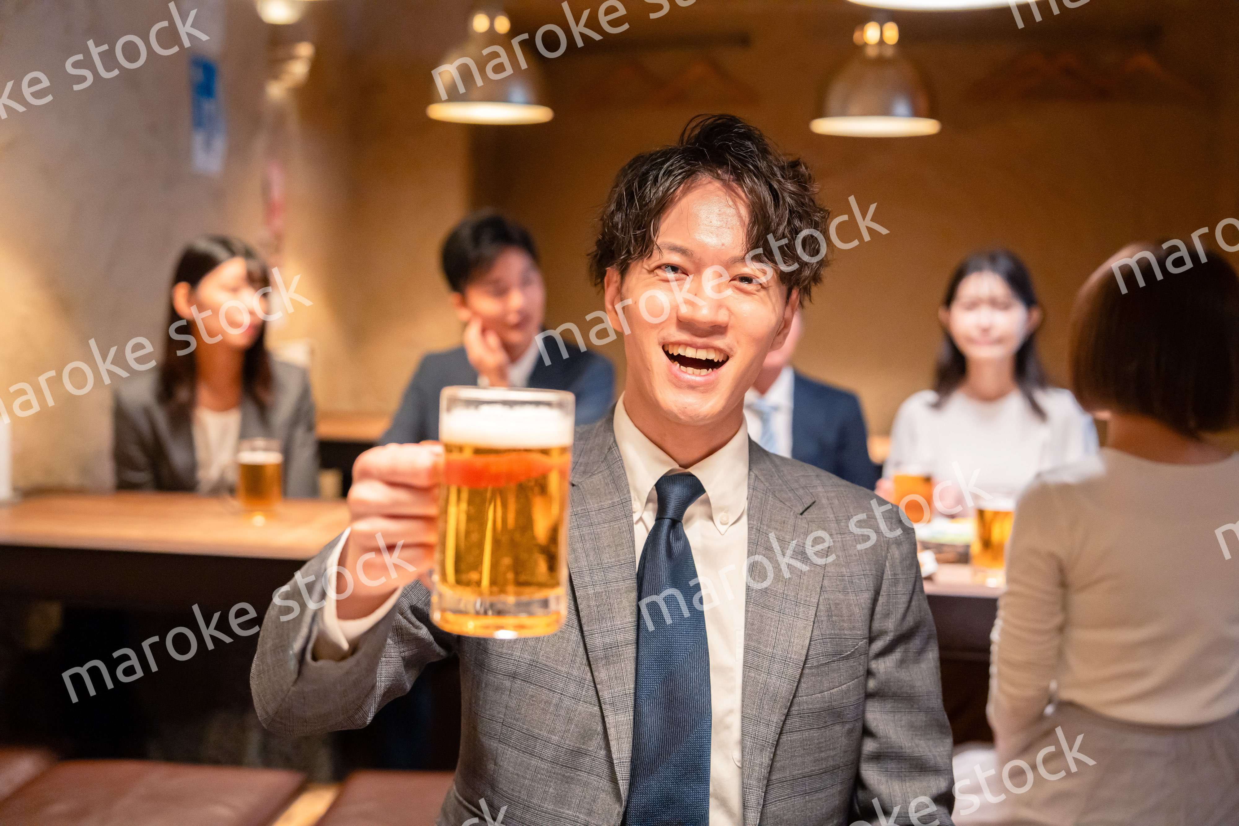 居酒屋でビールの乾杯をするサラリーマンの男性