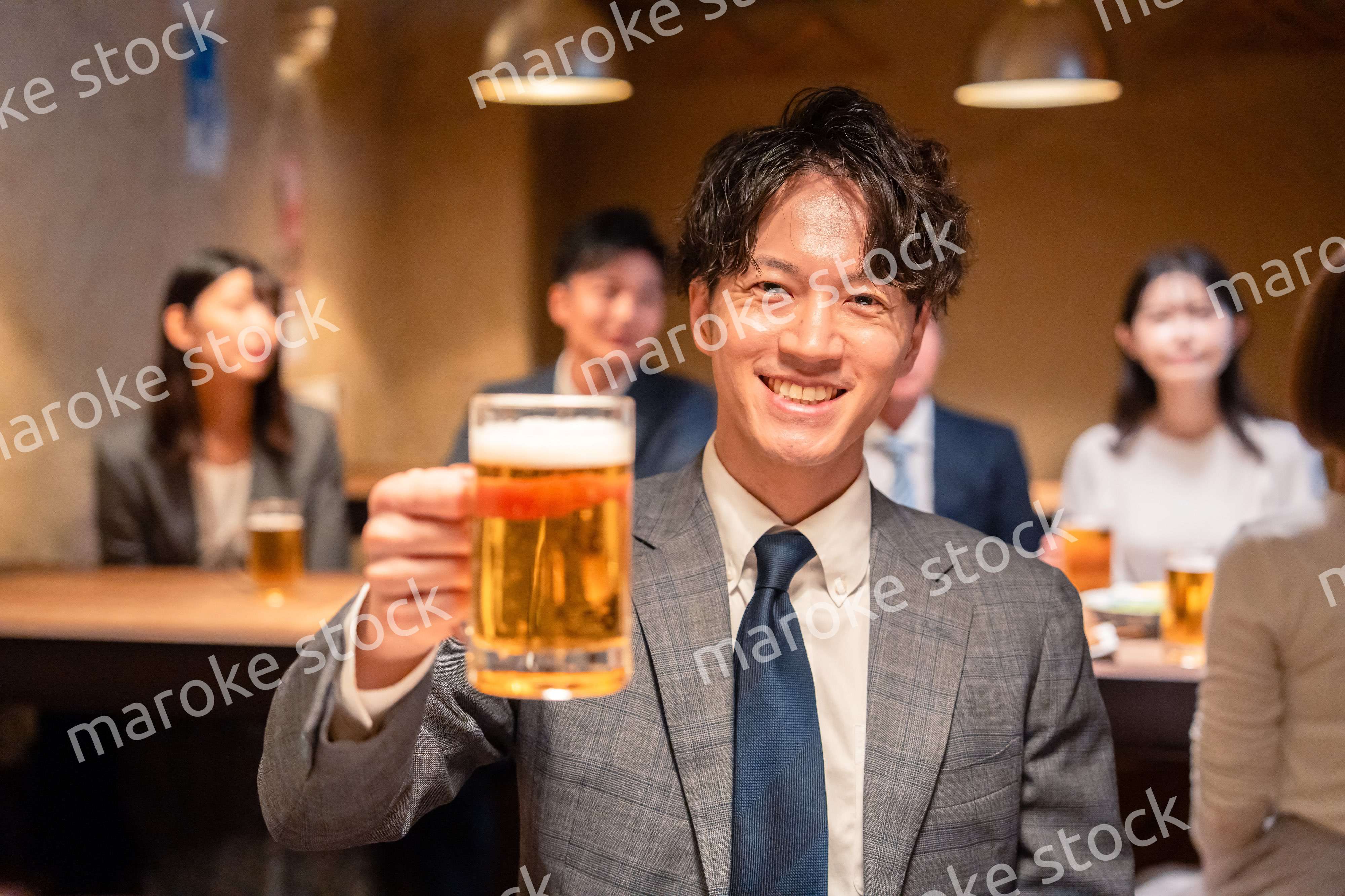 居酒屋でビールの乾杯をするサラリーマンの男性