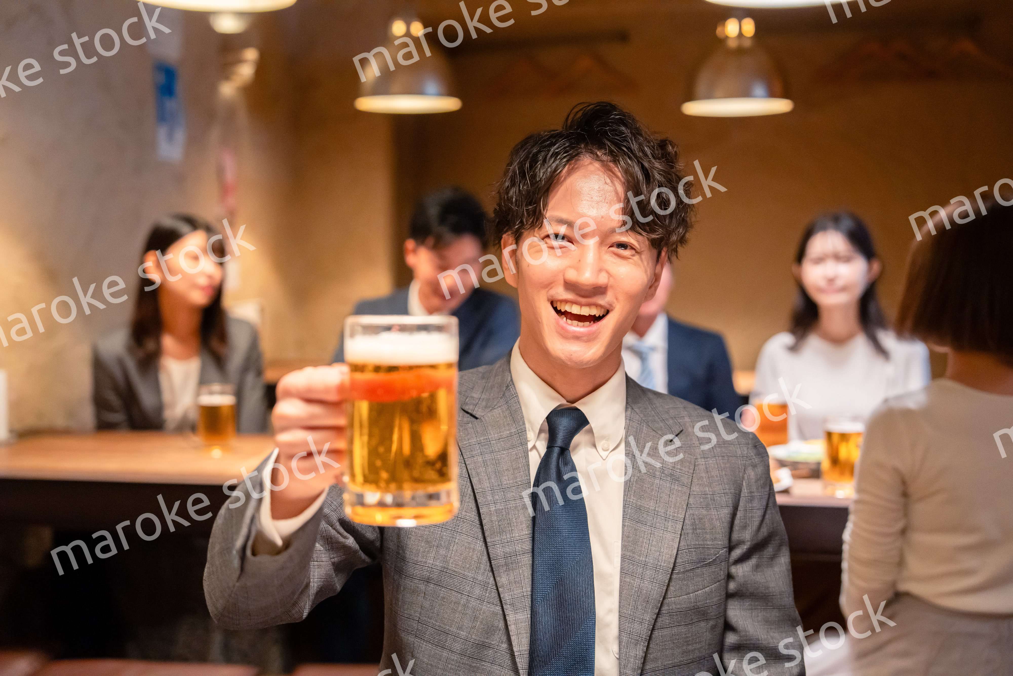 居酒屋でビールの乾杯をするサラリーマンの男性