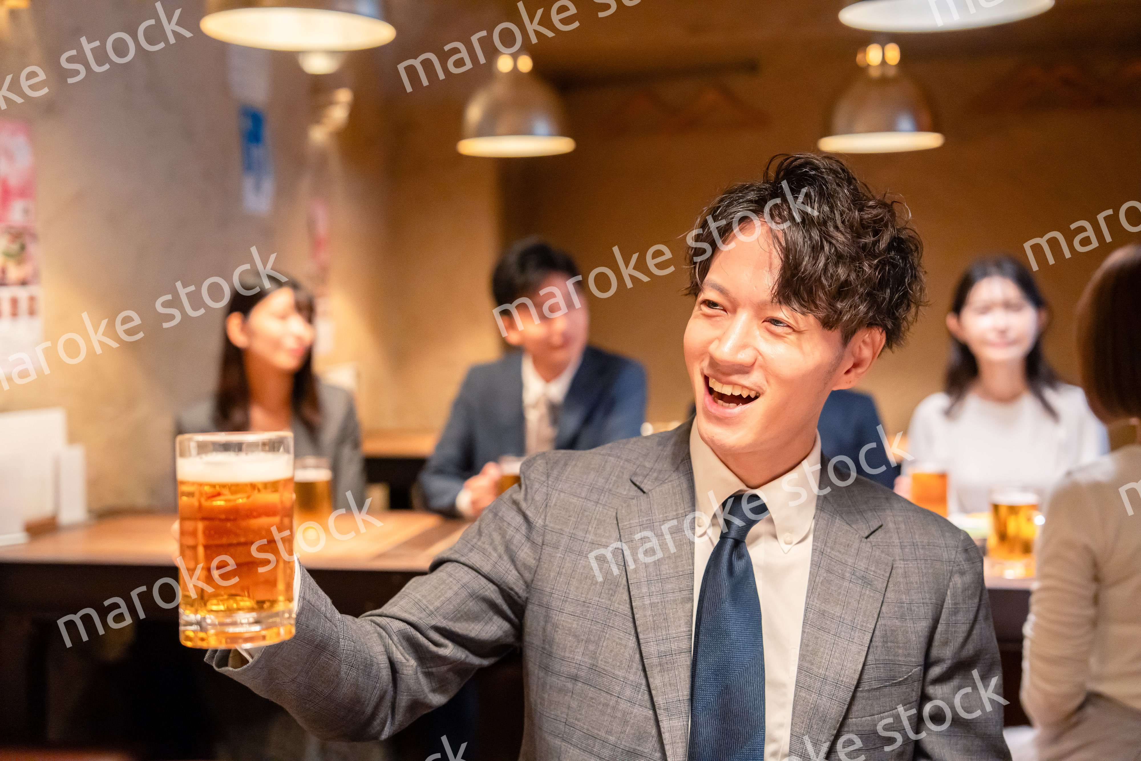 居酒屋でビールの乾杯をするサラリーマンの男性