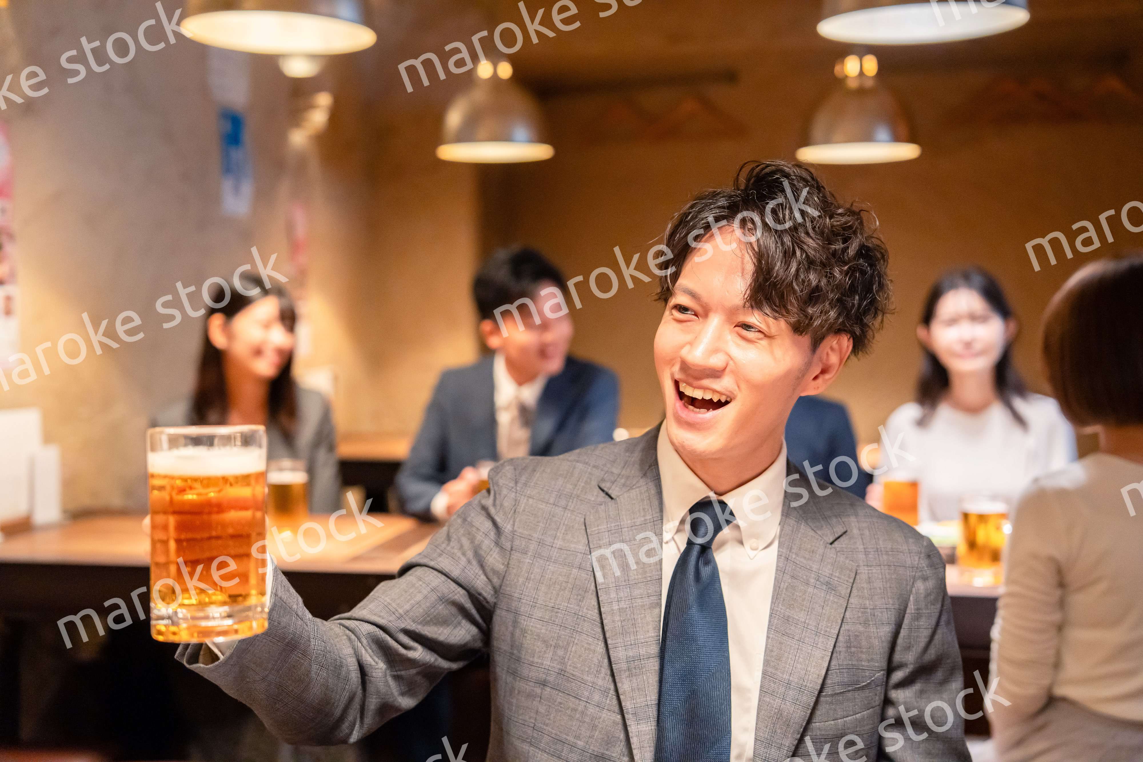 居酒屋でビールの乾杯をするサラリーマンの男性
