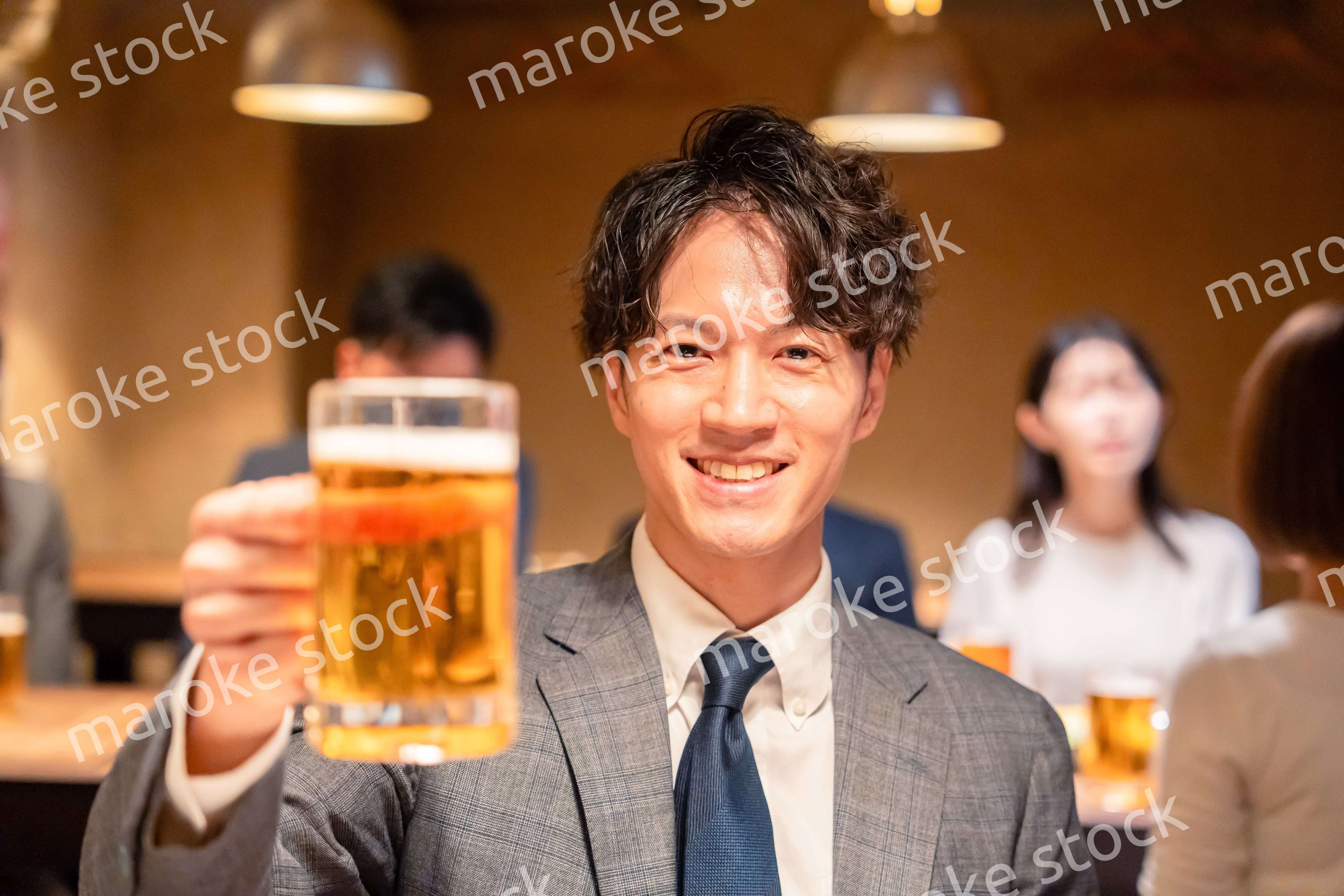 居酒屋でビールの乾杯をするサラリーマンの男性