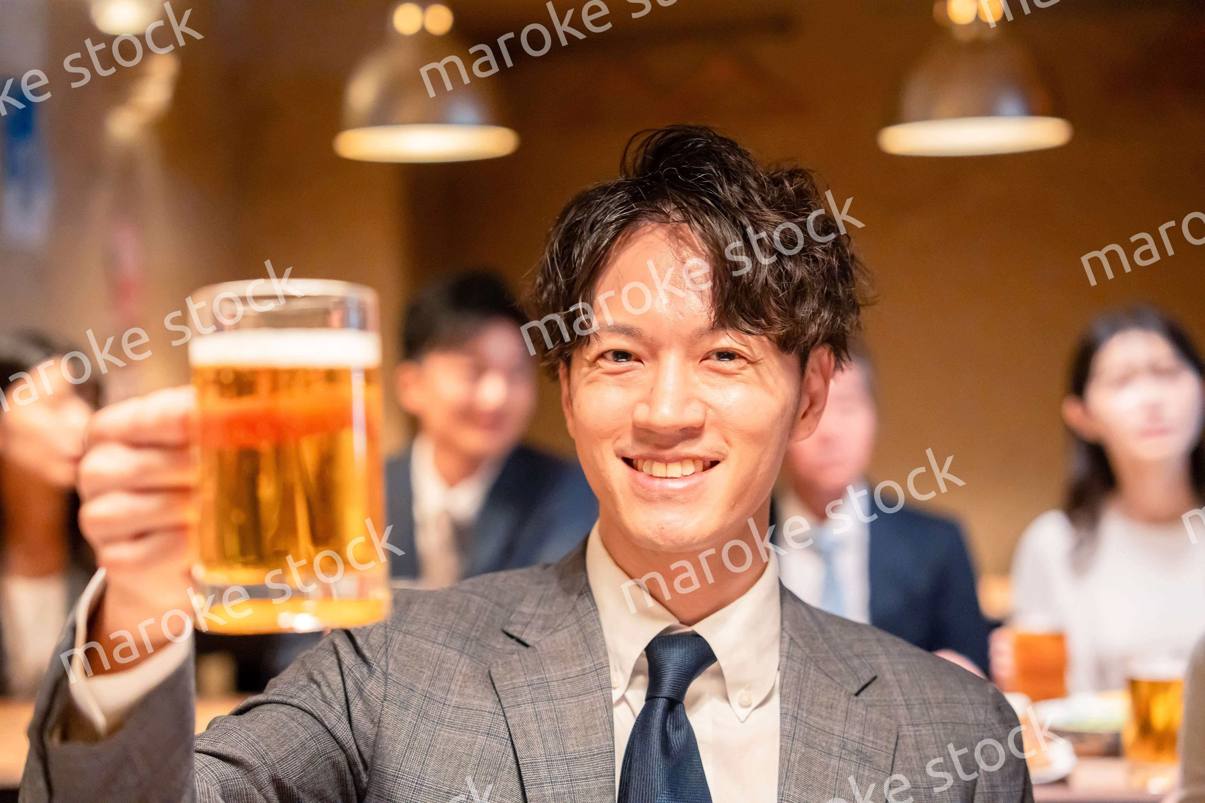 居酒屋でビールの乾杯をするサラリーマンの男性