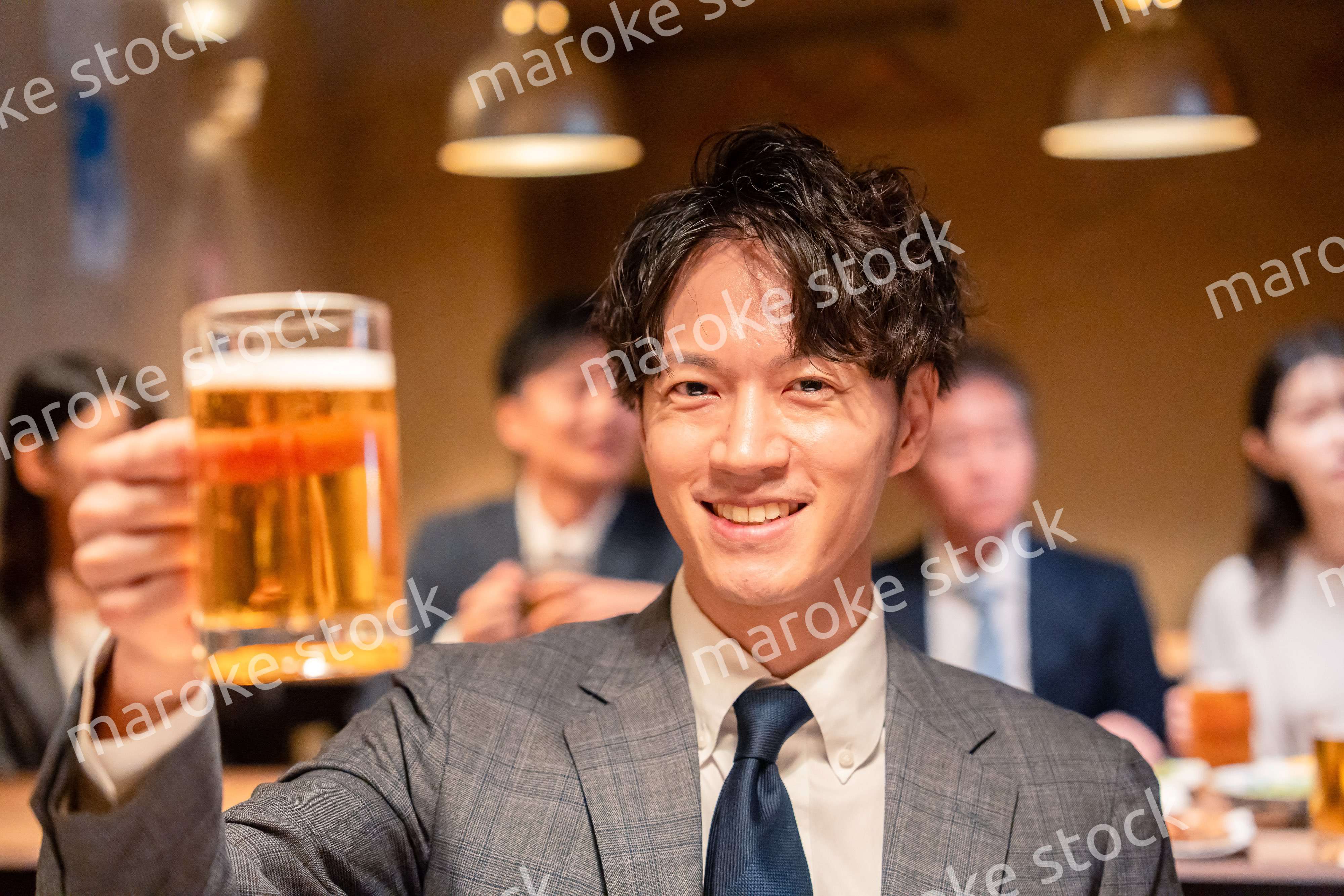 居酒屋でビールの乾杯をするサラリーマンの男性