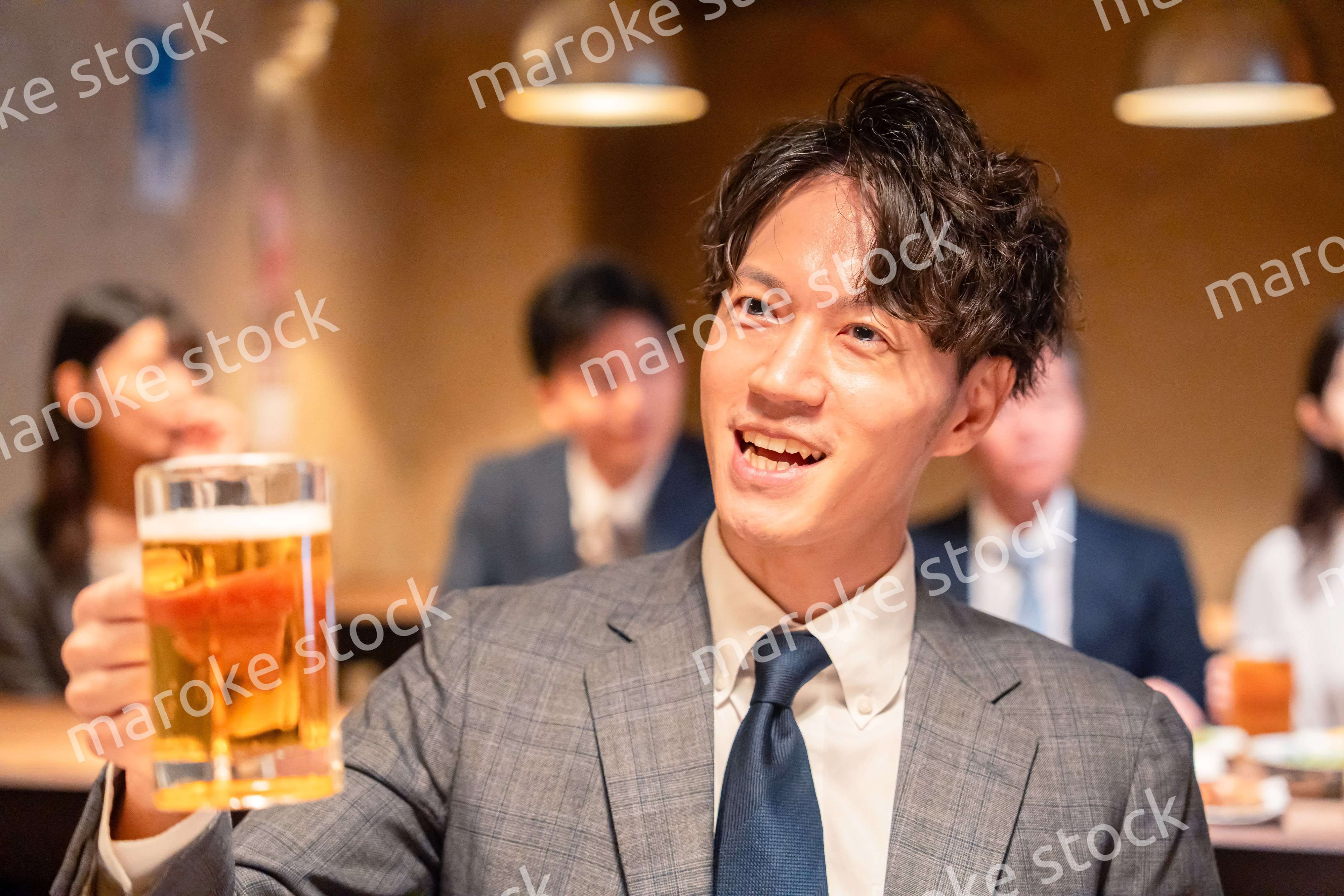 居酒屋でビールの乾杯をするサラリーマンの男性