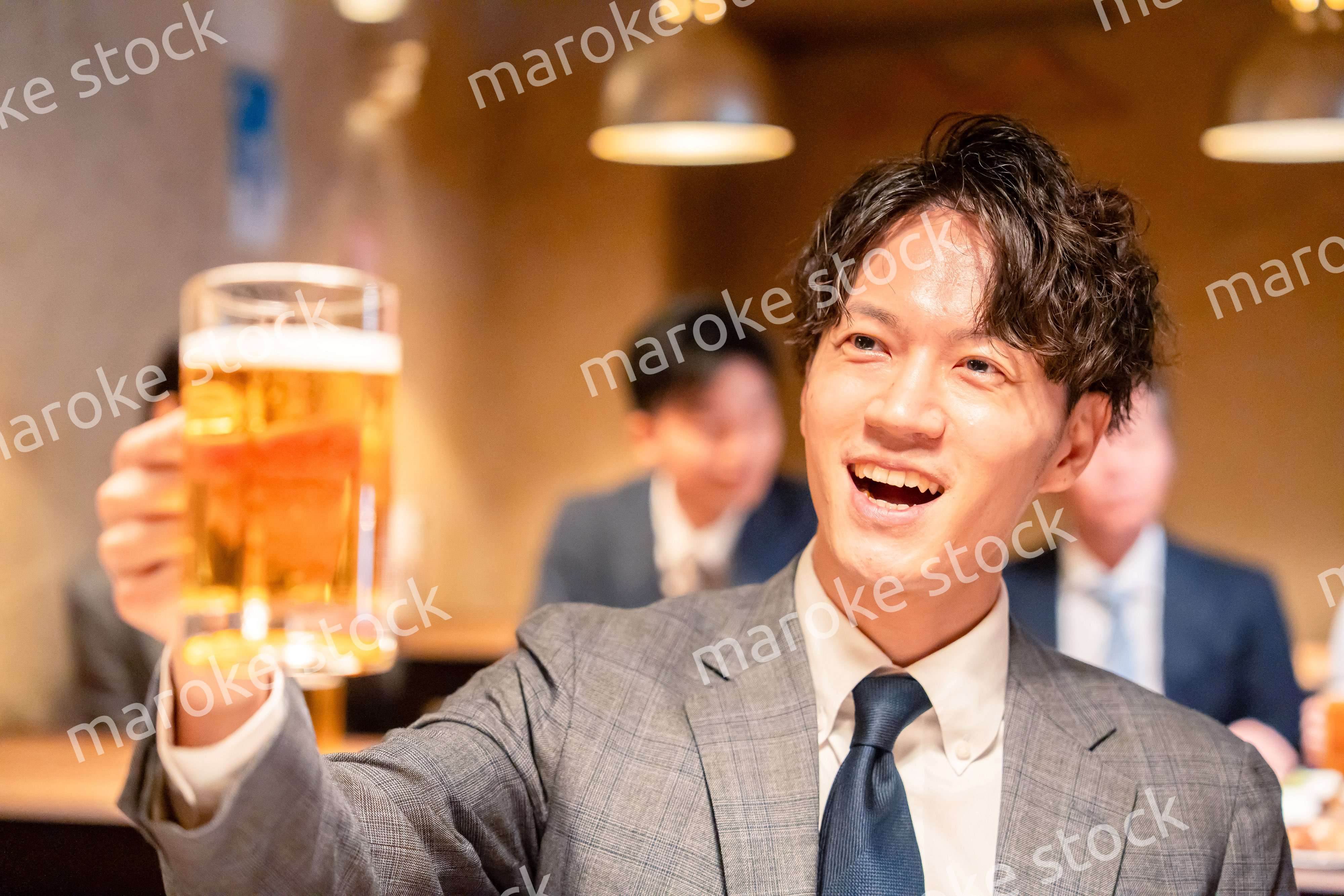 居酒屋でビールの乾杯をするサラリーマンの男性