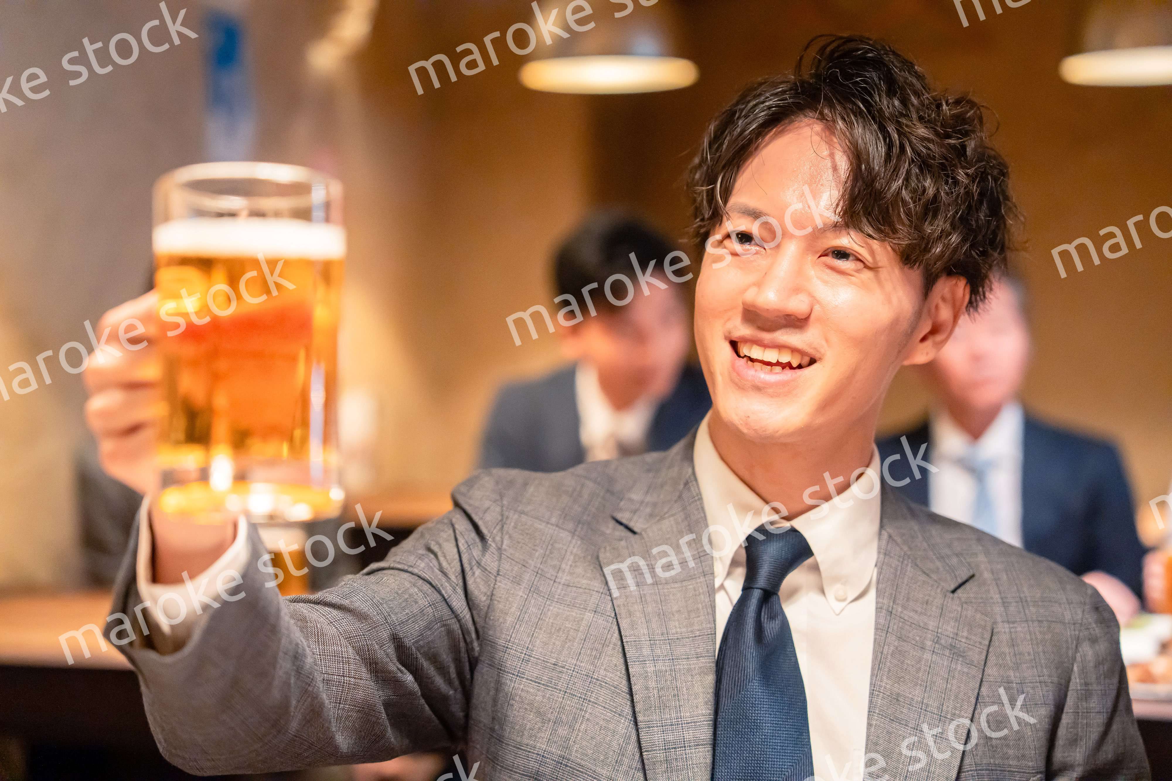 居酒屋でビールの乾杯をするサラリーマンの男性