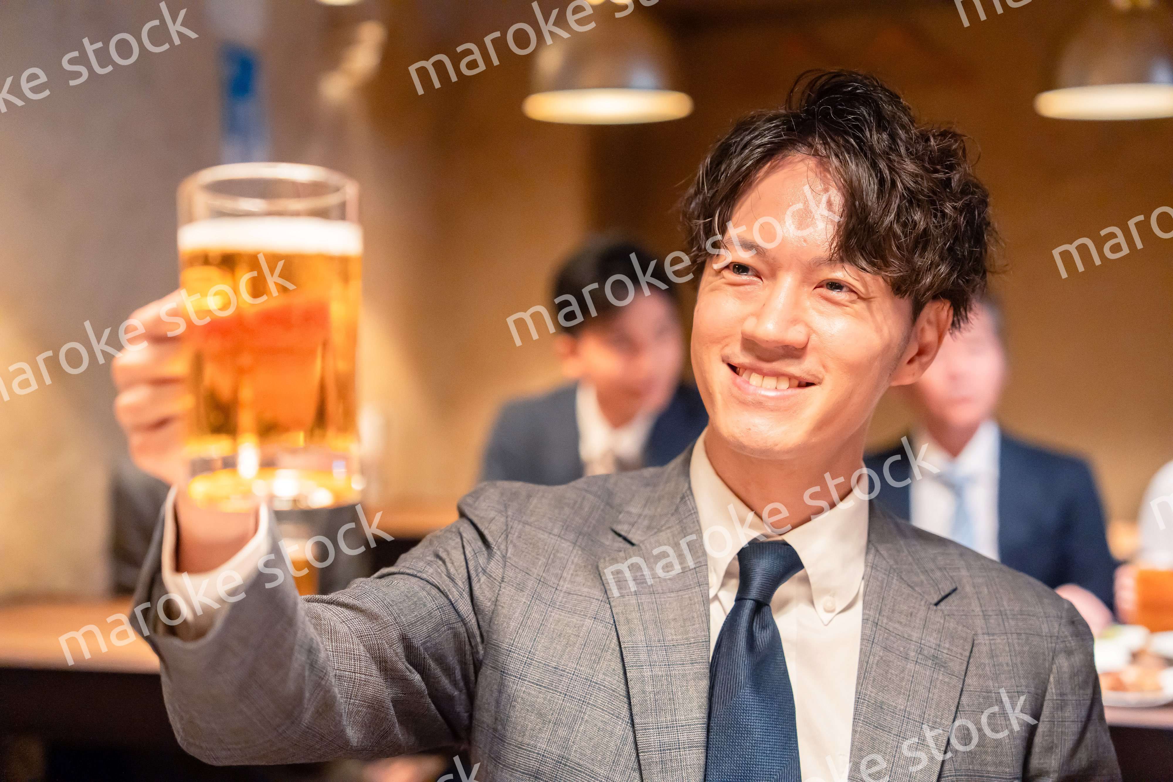 居酒屋でビールの乾杯をするサラリーマンの男性