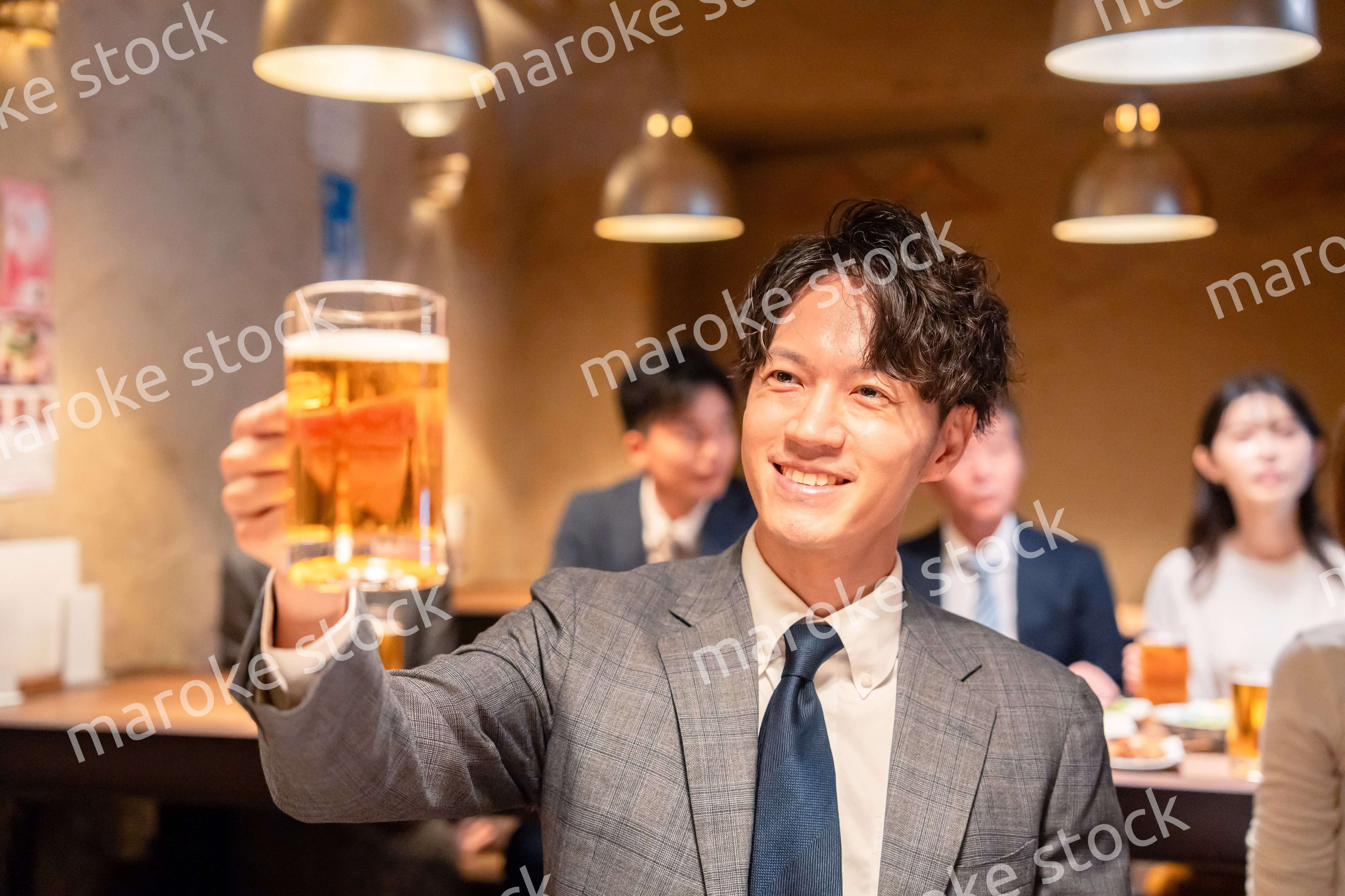 居酒屋でビールの乾杯をするサラリーマンの男性