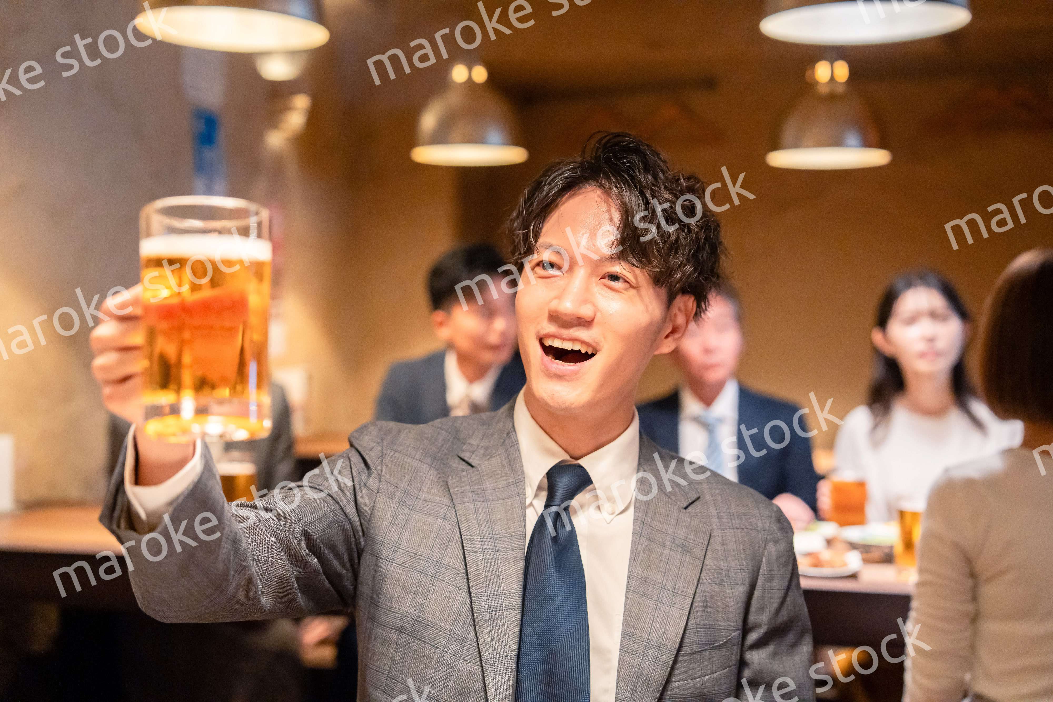 居酒屋でビールの乾杯をするサラリーマンの男性