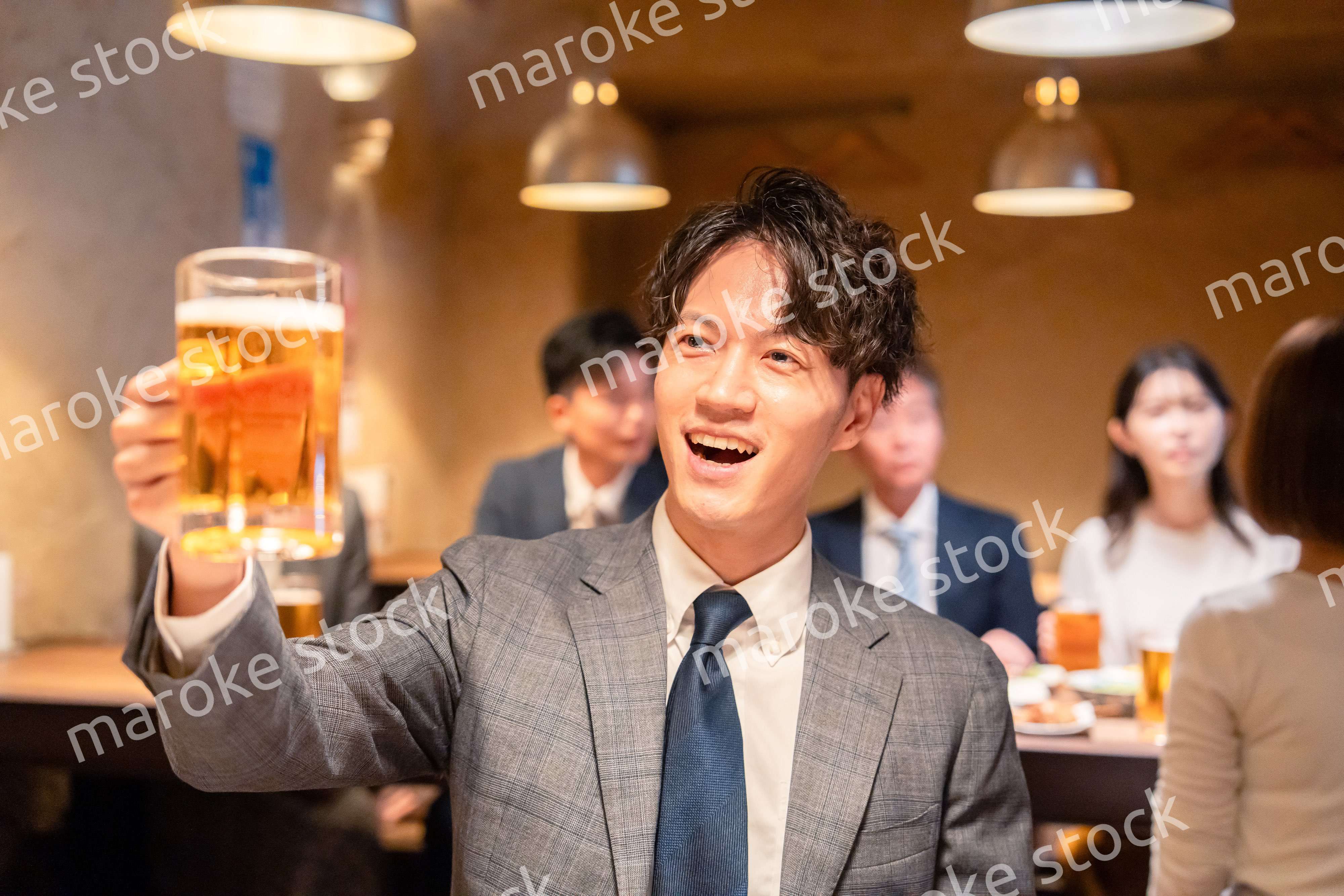 居酒屋でビールの乾杯をするサラリーマンの男性