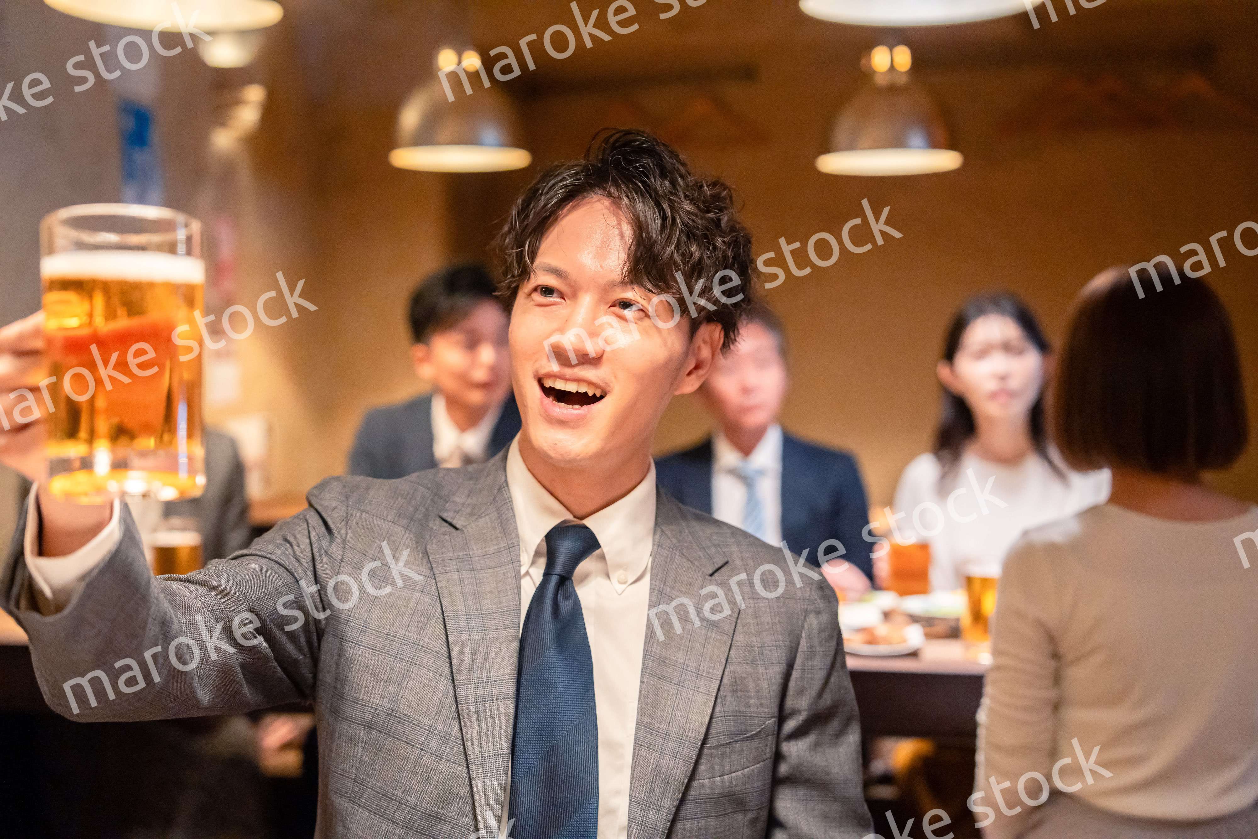 居酒屋でビールの乾杯をするサラリーマンの男性