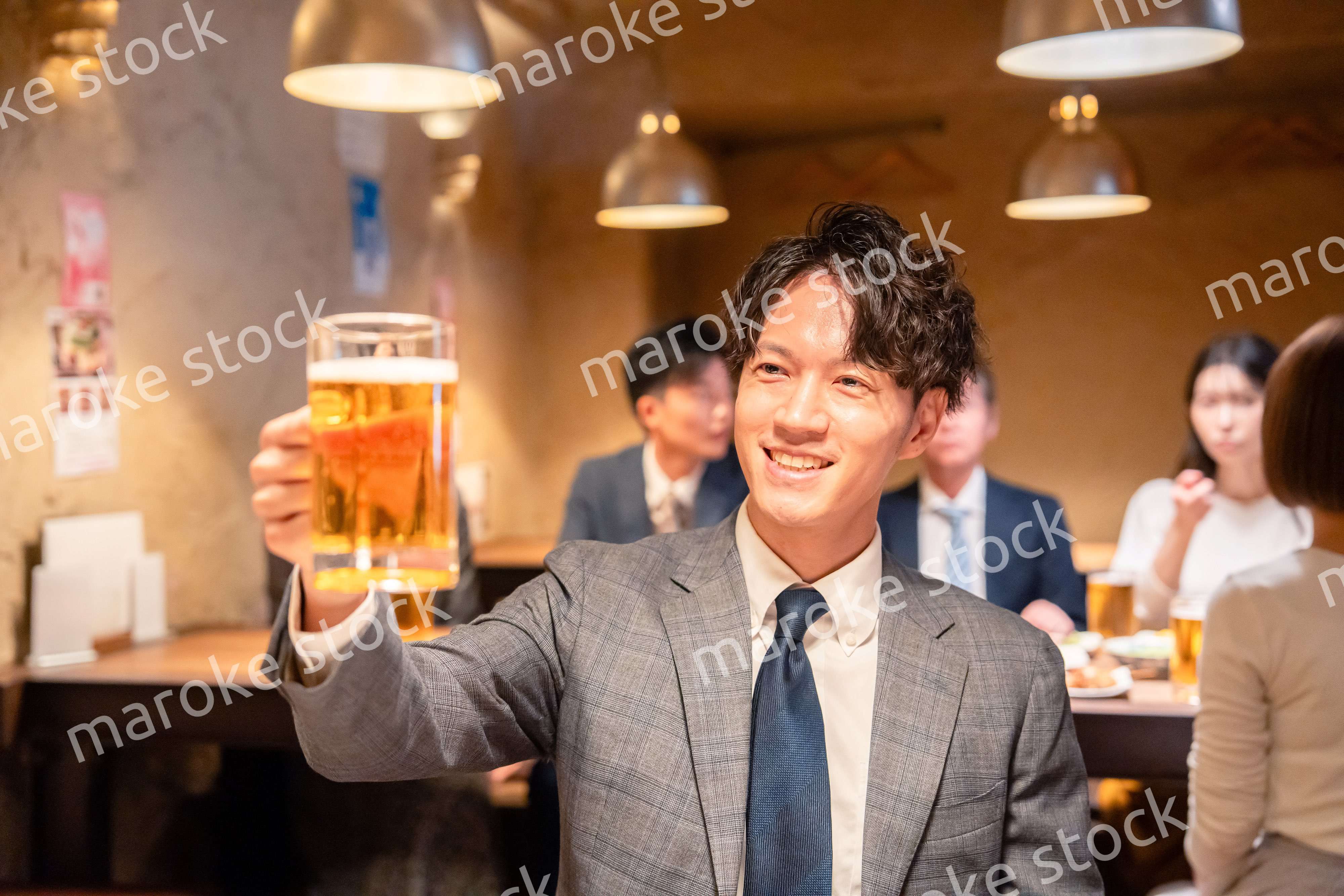 居酒屋でビールの乾杯をするサラリーマンの男性