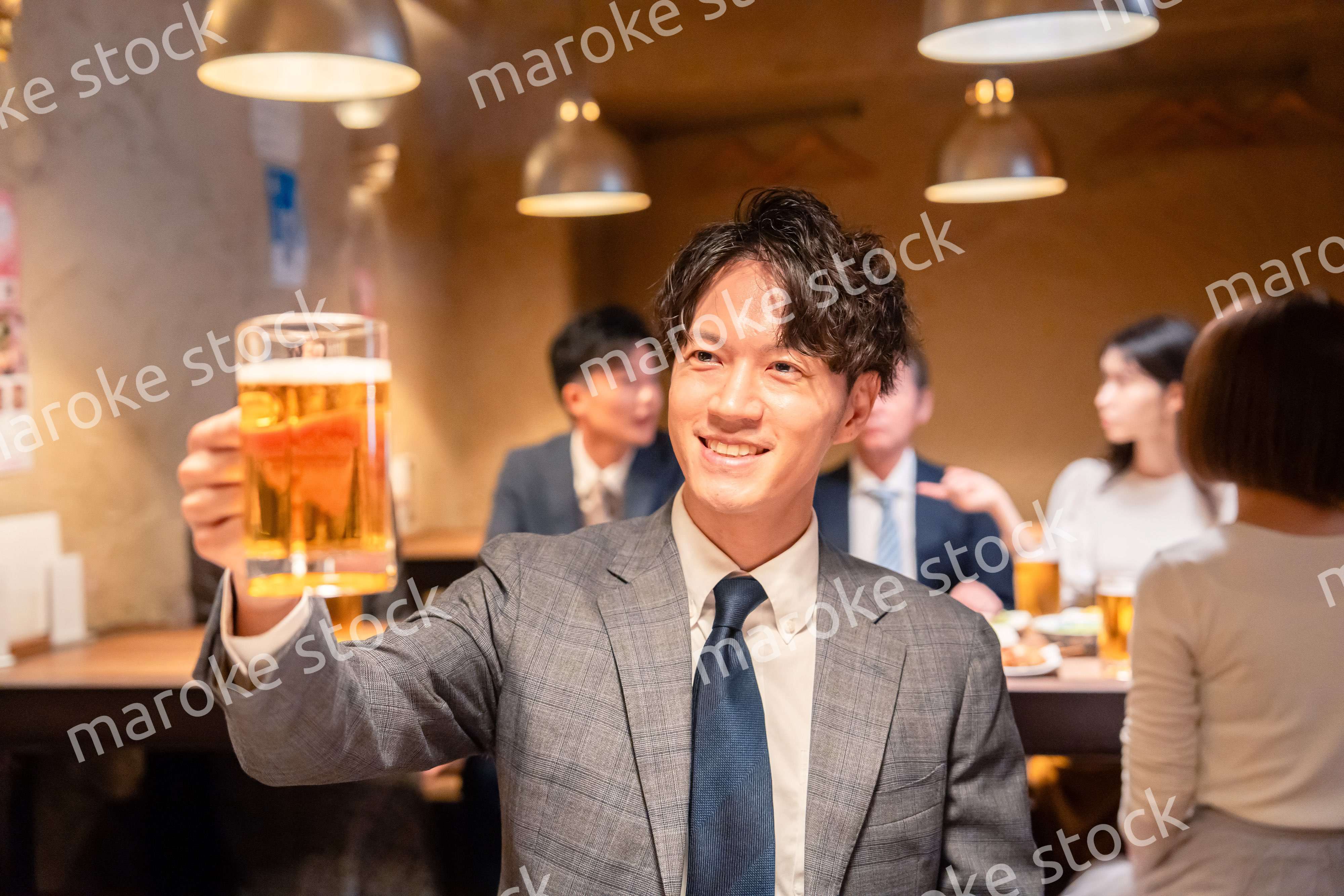 居酒屋でビールの乾杯をするサラリーマンの男性