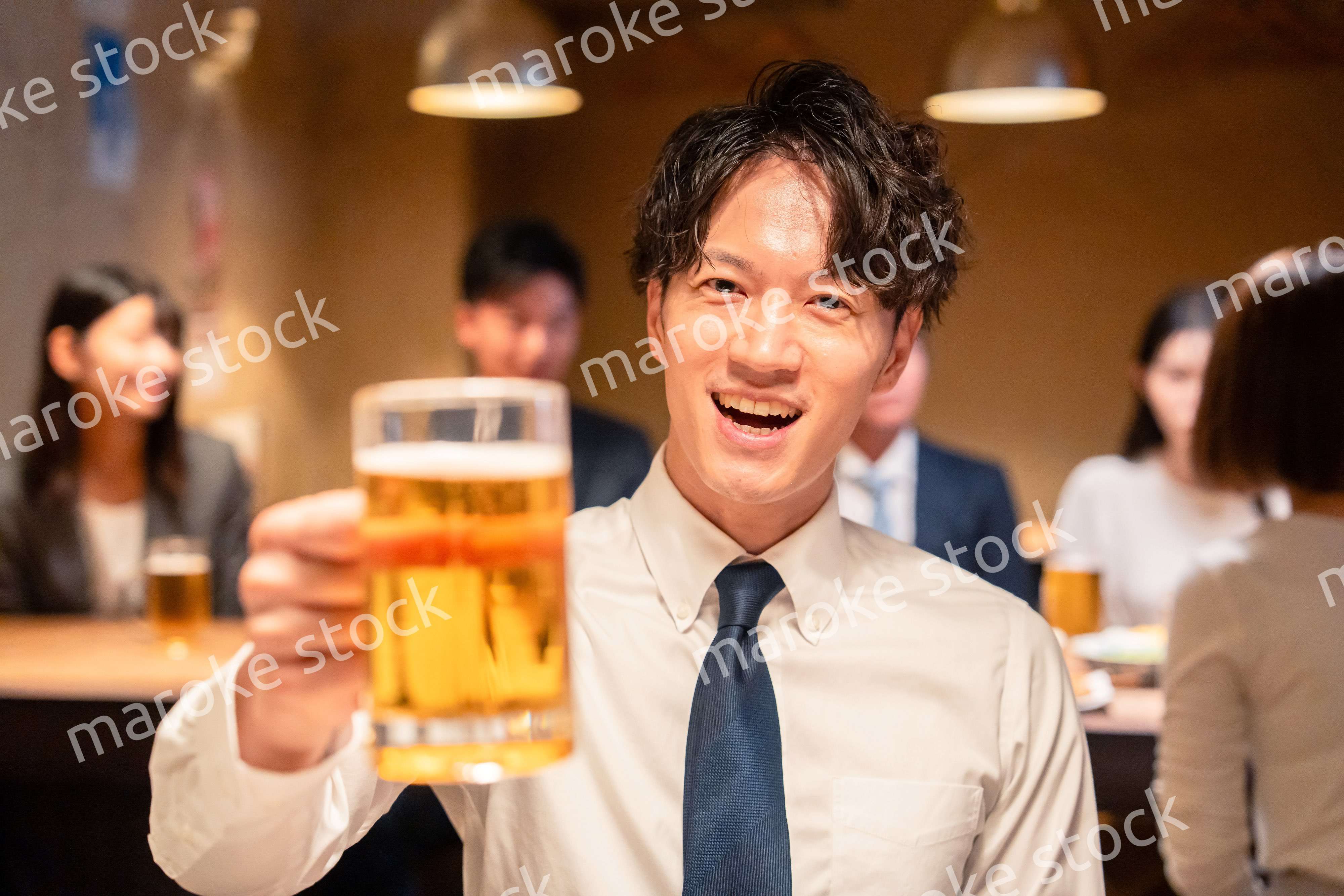 居酒屋でビールの乾杯をするサラリーマンの男性