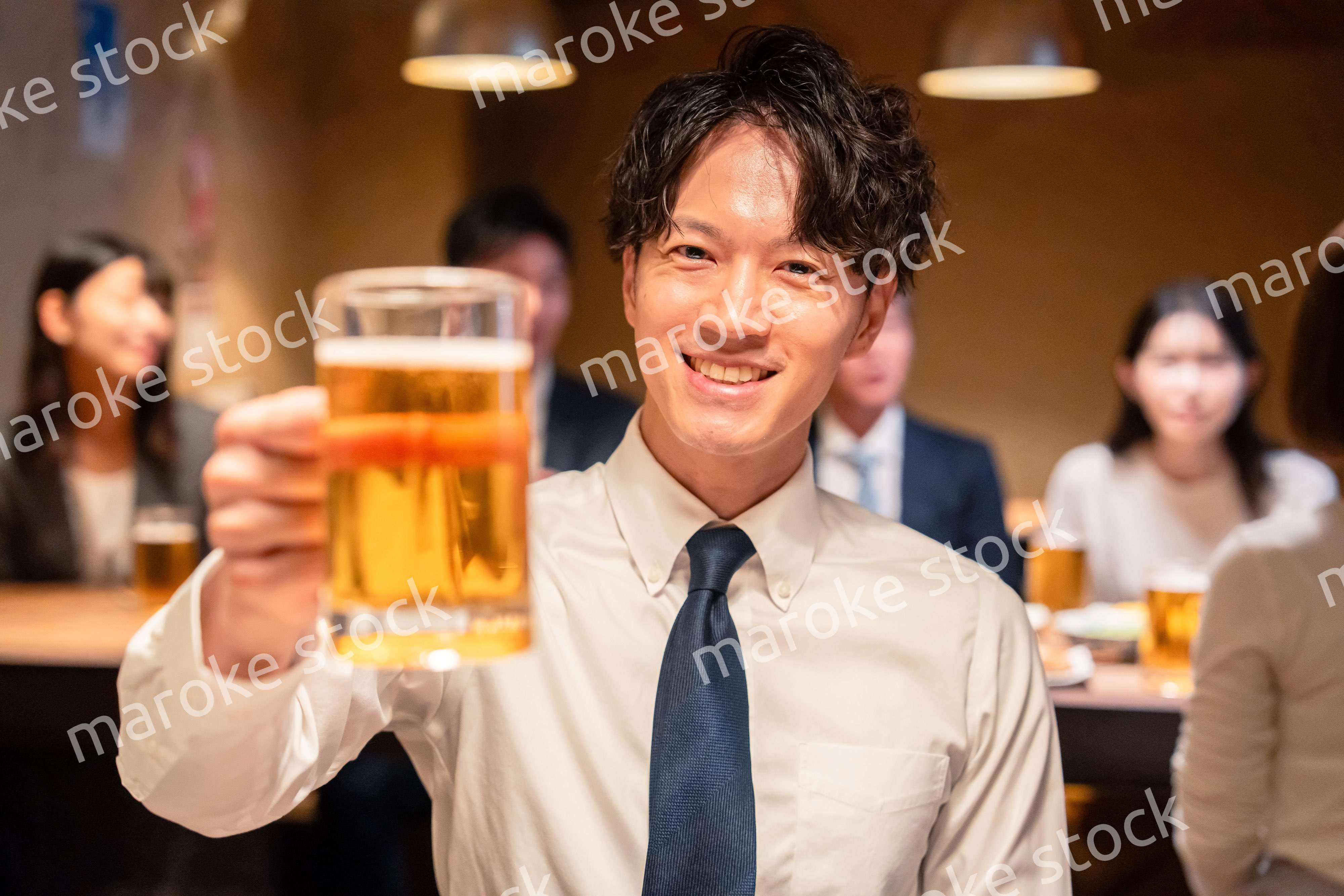 居酒屋でビールの乾杯をするサラリーマンの男性