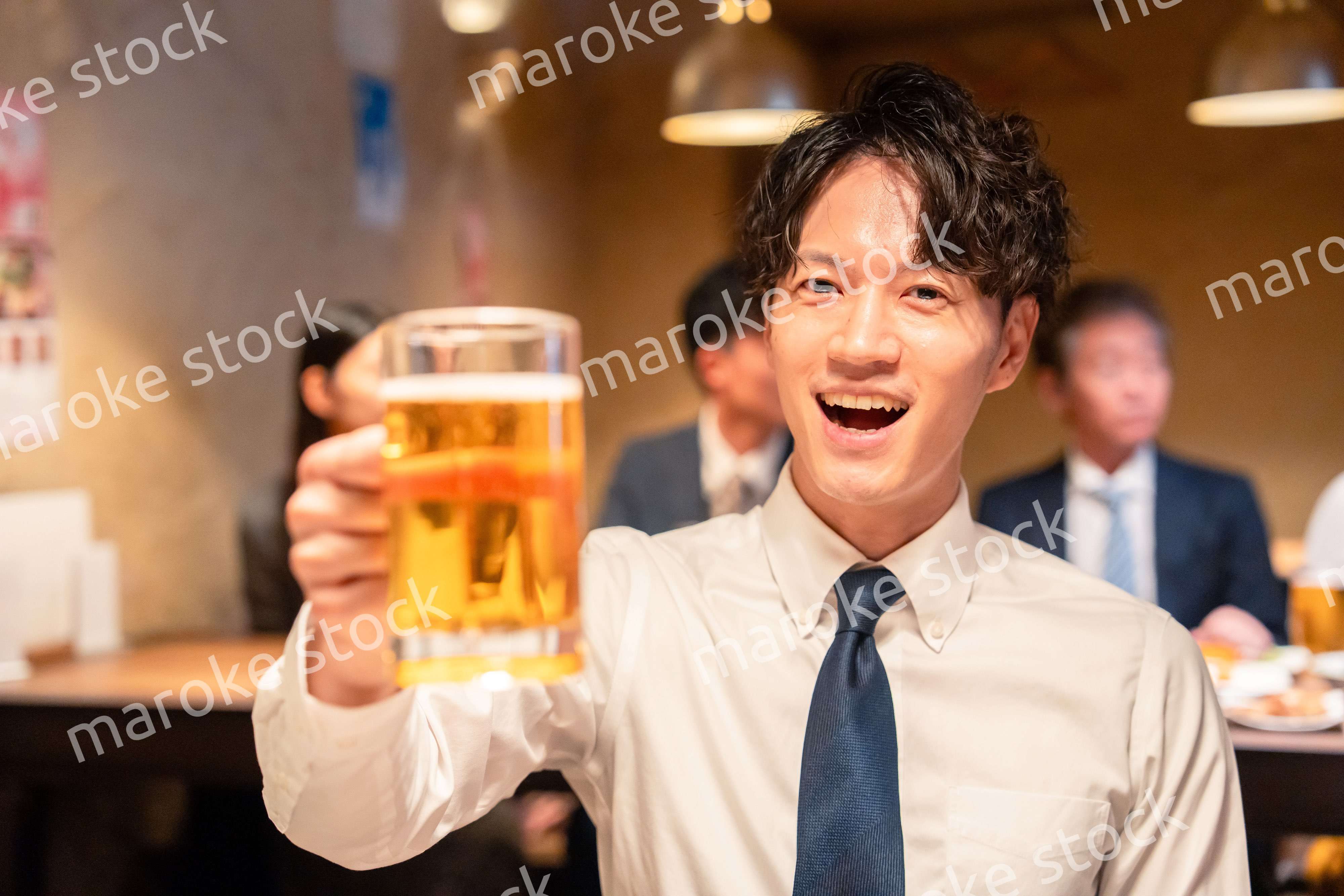 居酒屋でビールの乾杯をするサラリーマンの男性