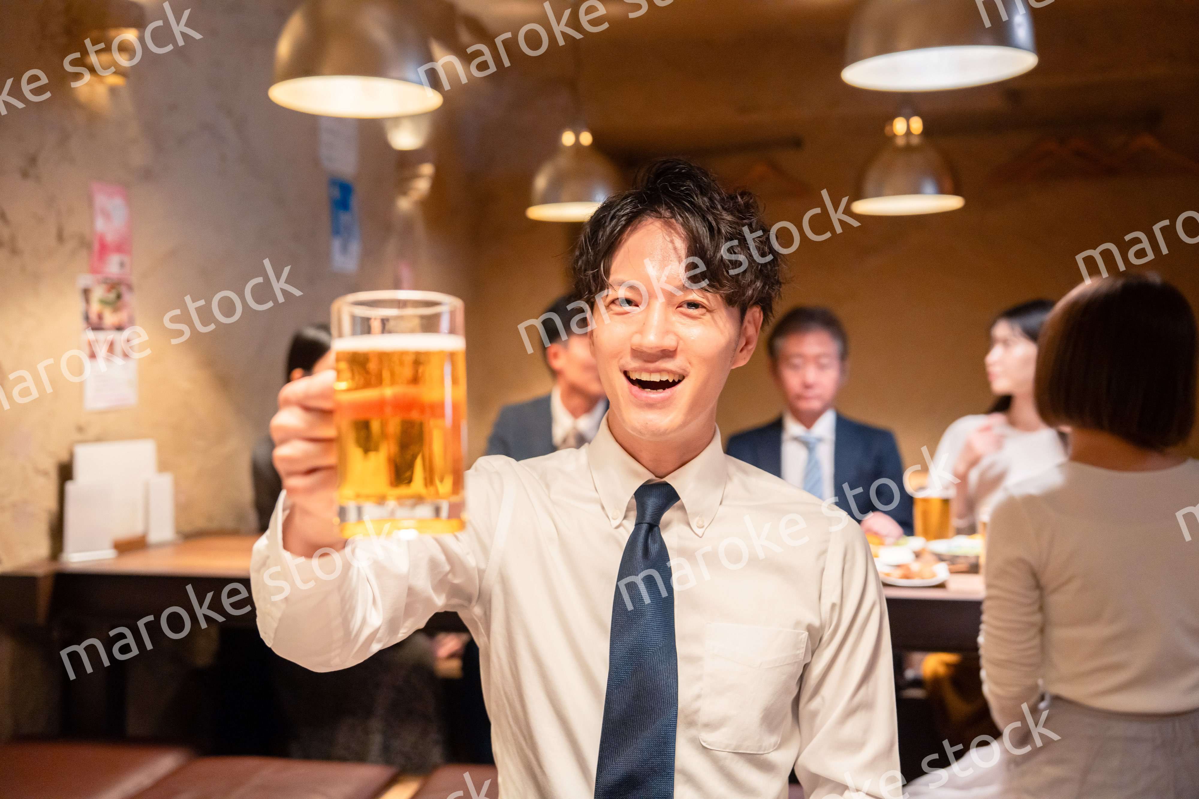 居酒屋でビールの乾杯をするサラリーマンの男性