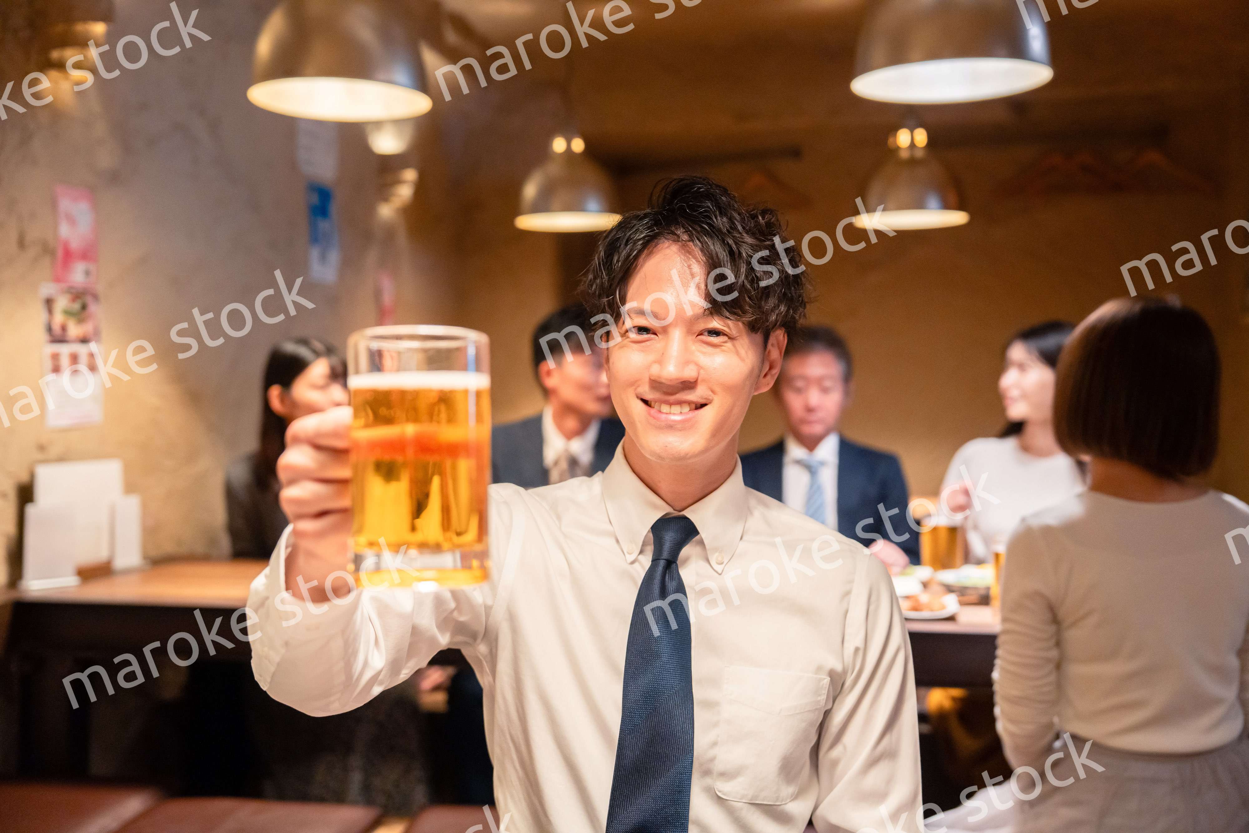 居酒屋でビールの乾杯をするサラリーマンの男性