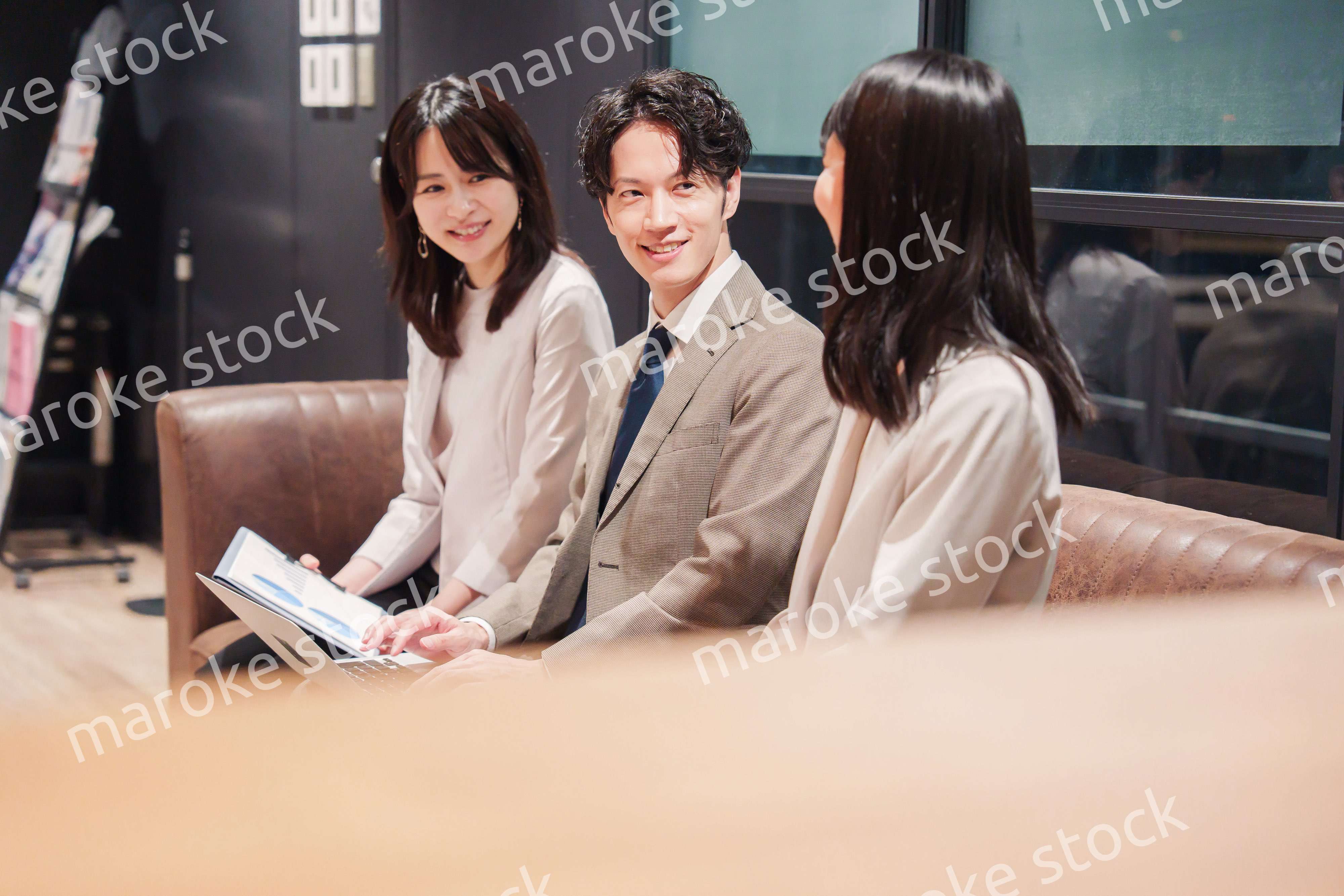 オフィスのソファーでカジュアルに打ち合わせをするビジネスパーソン