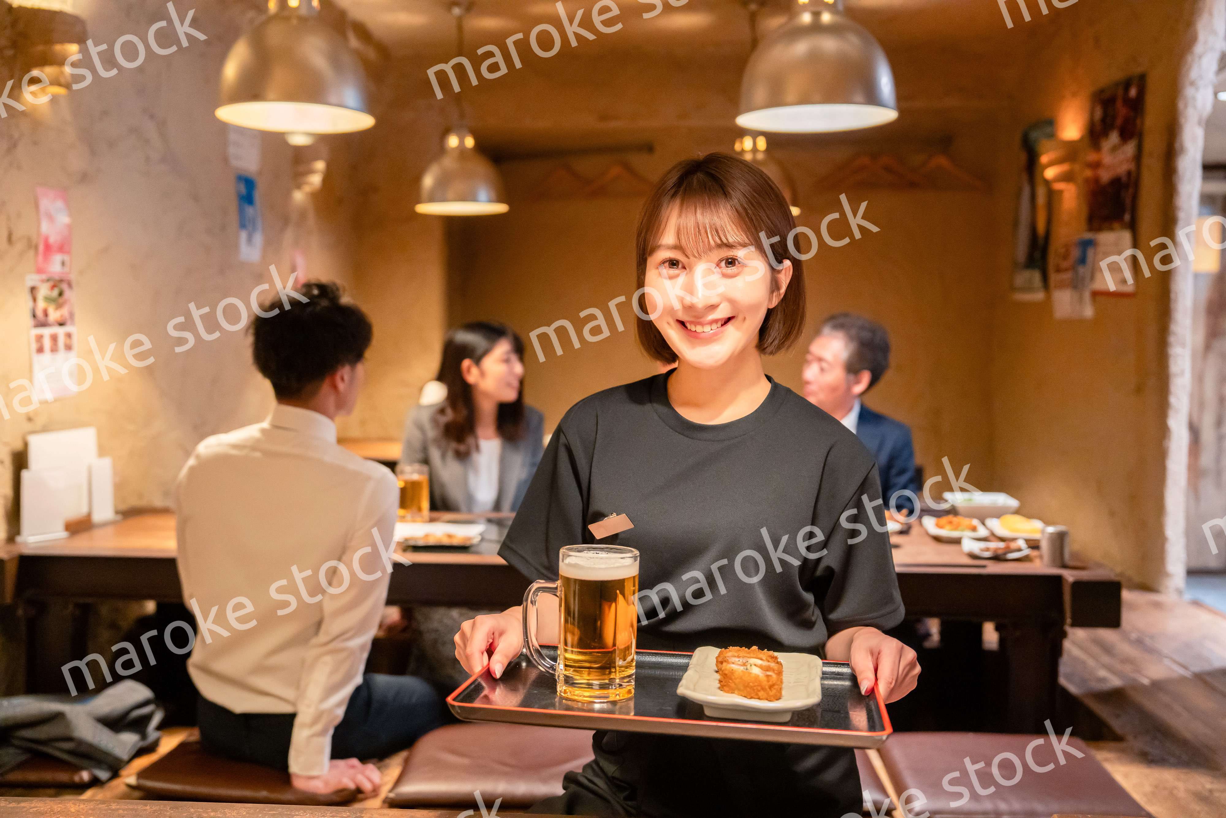 居酒屋のホールで働く若い女性