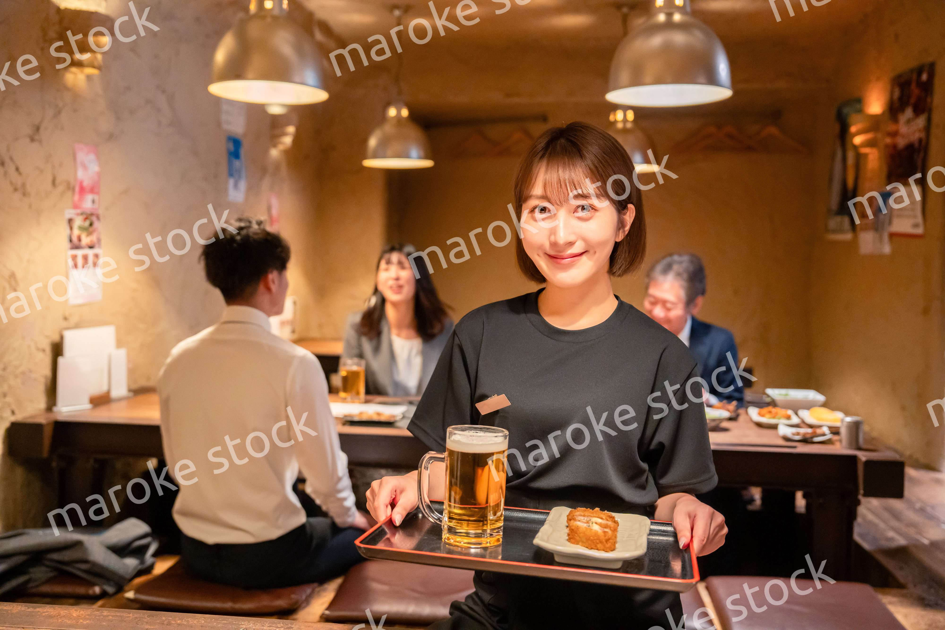 居酒屋のホールで働く若い女性