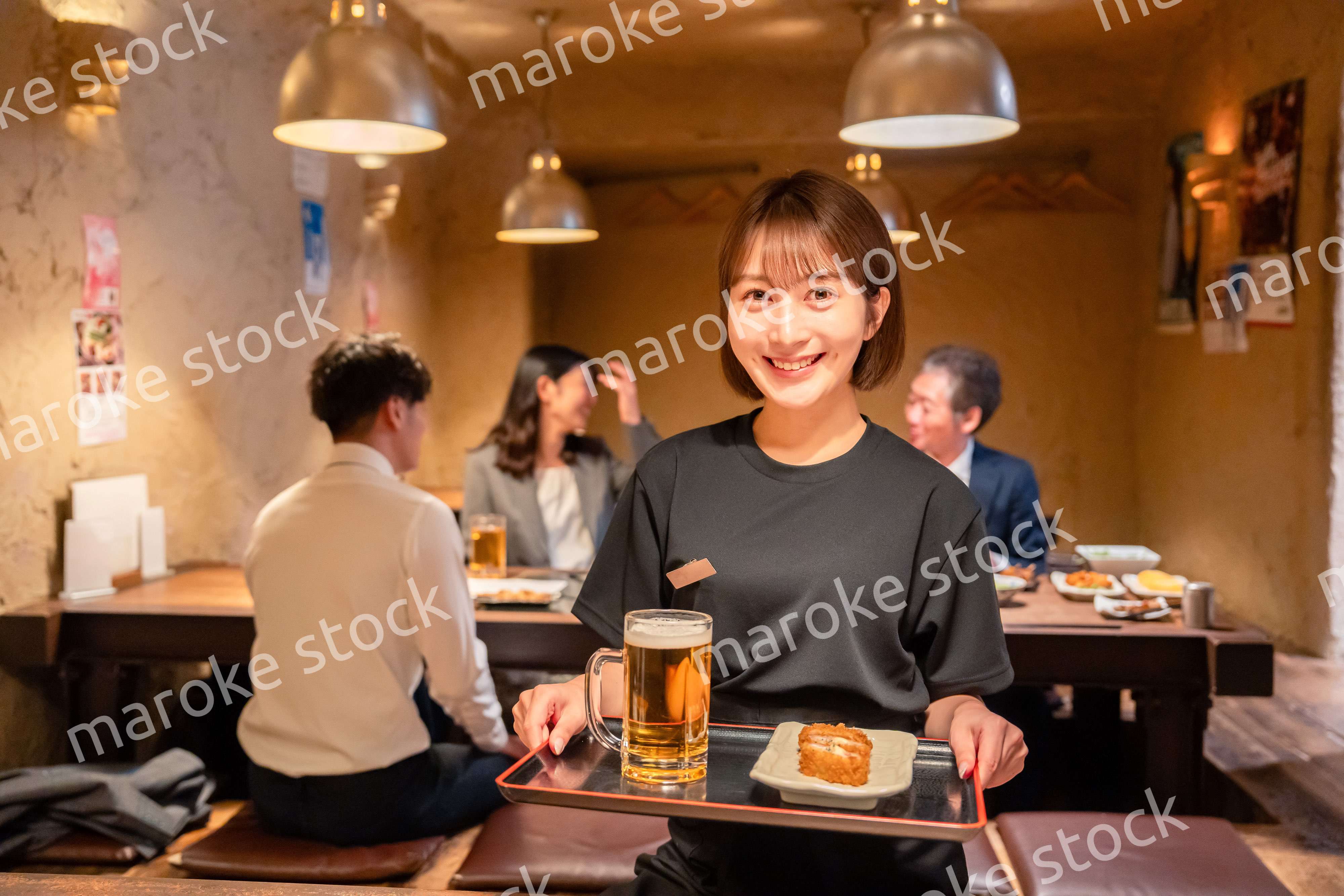 居酒屋のホールで働く若い女性