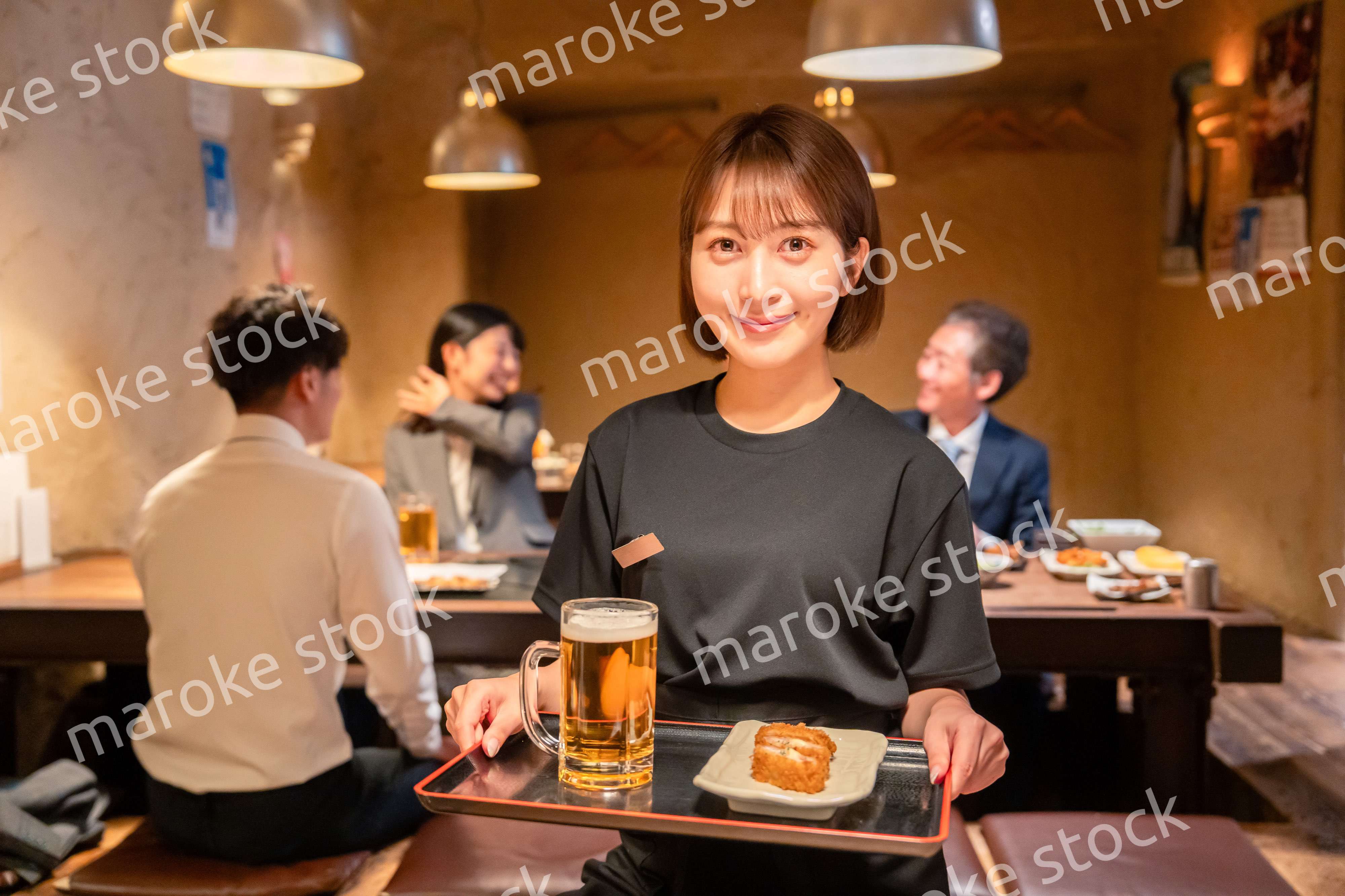 居酒屋のホールで働く若い女性