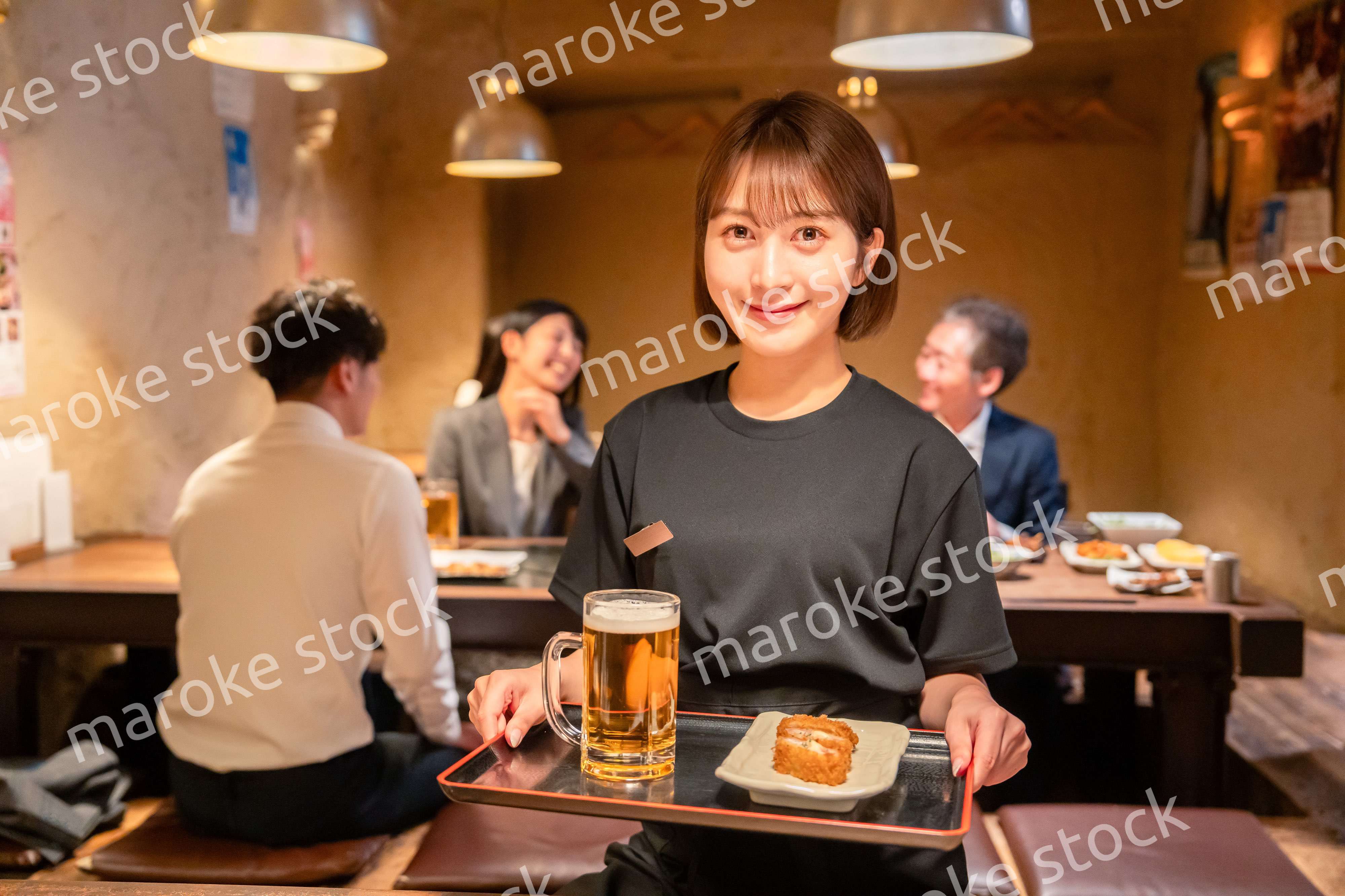 居酒屋のホールで働く若い女性