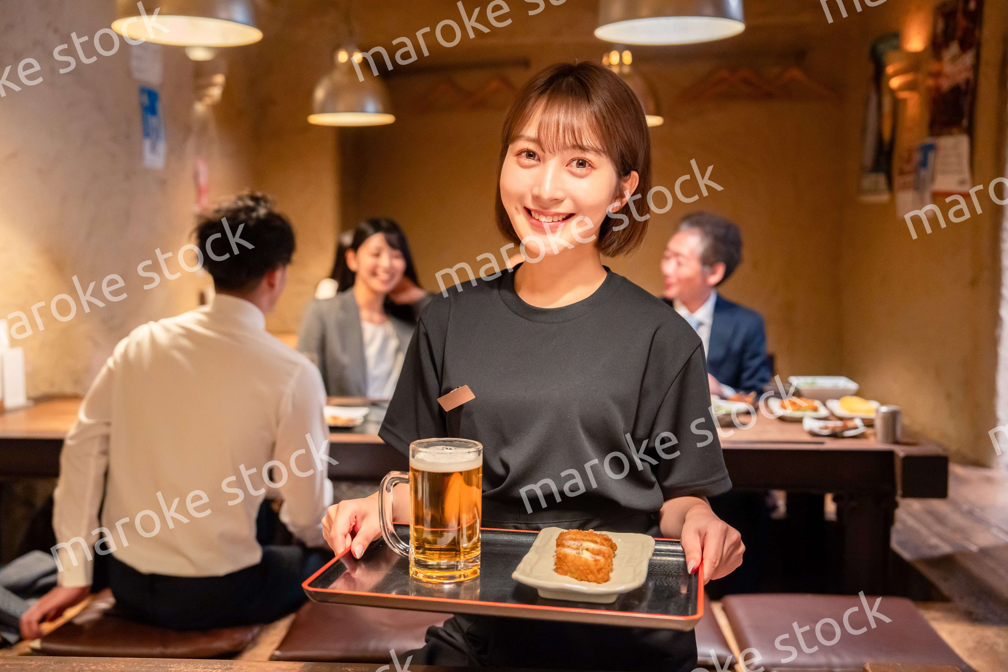 居酒屋のホールで働く若い女性