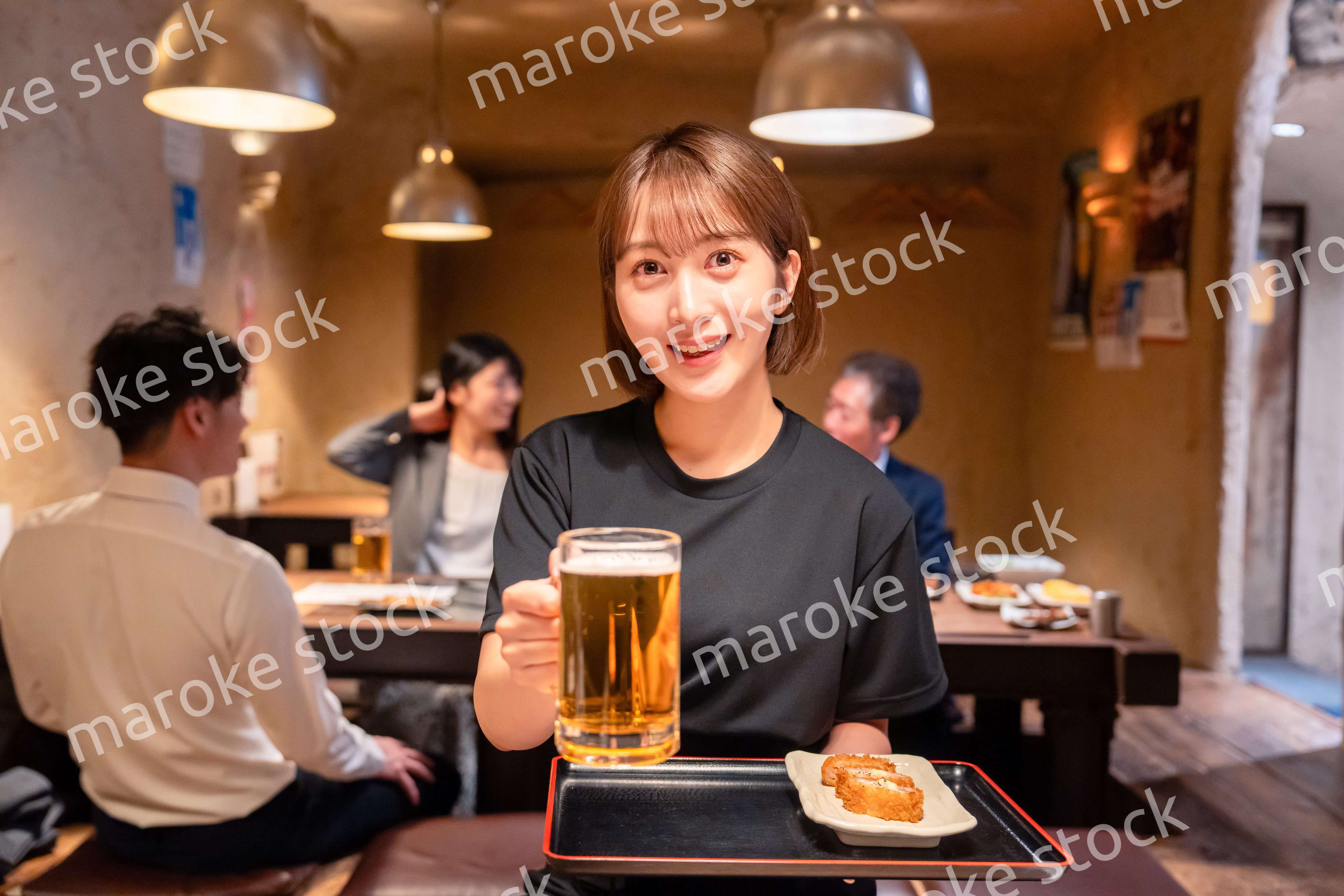 ビールを提供する居酒屋の女性スタッフ