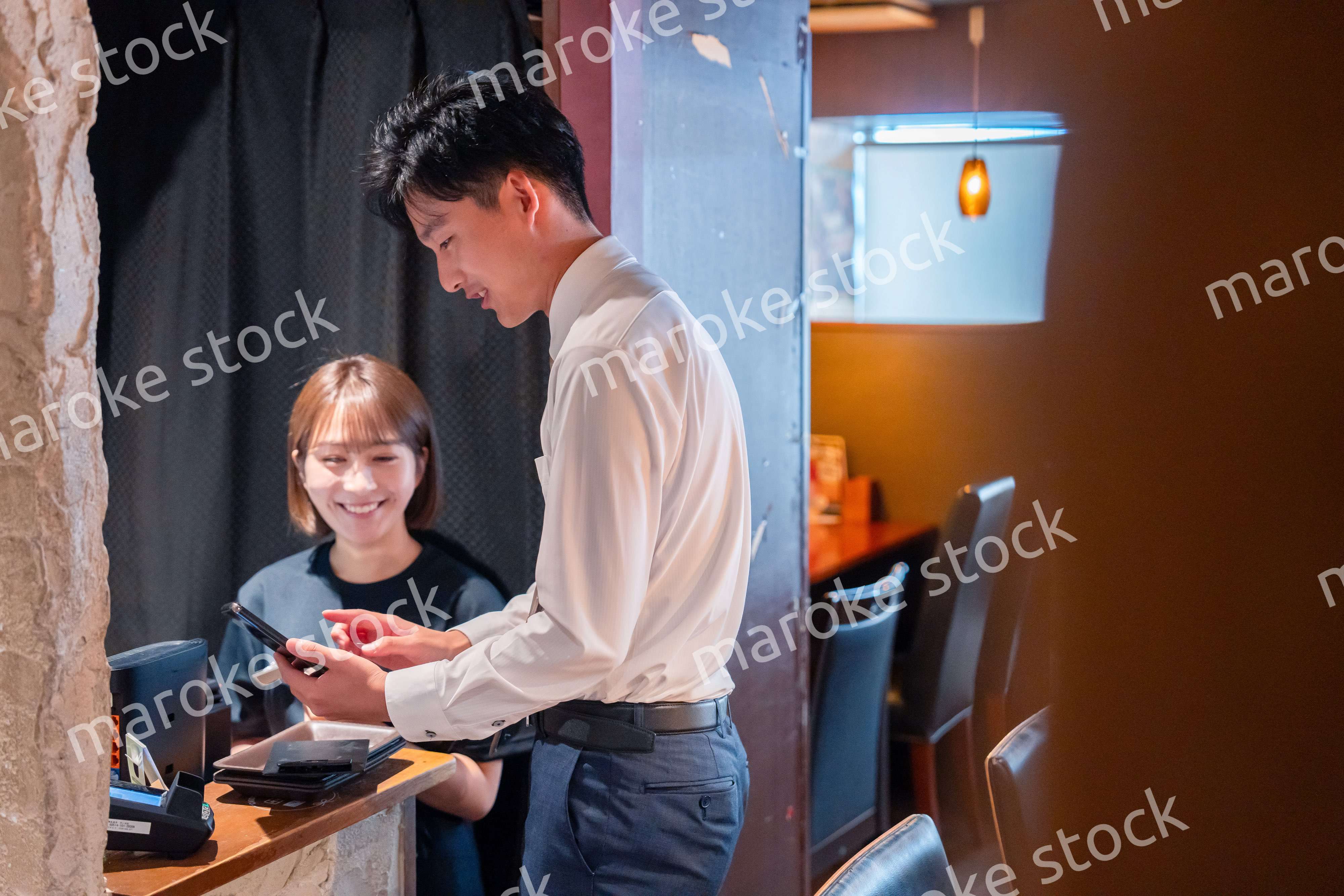 居酒屋でレジ打ちをする店員