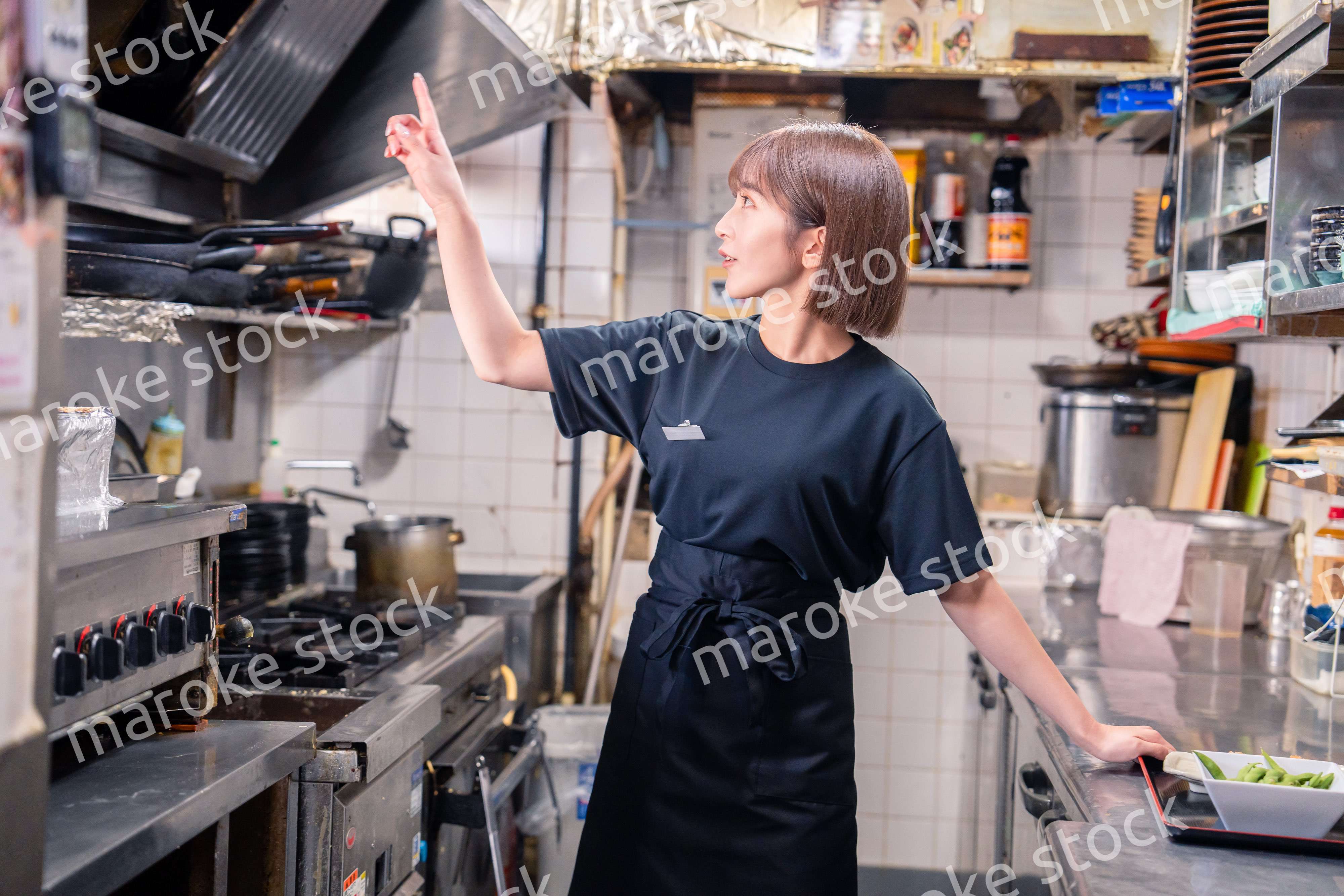 居酒屋の厨房で働くキッチンスタッフの女性