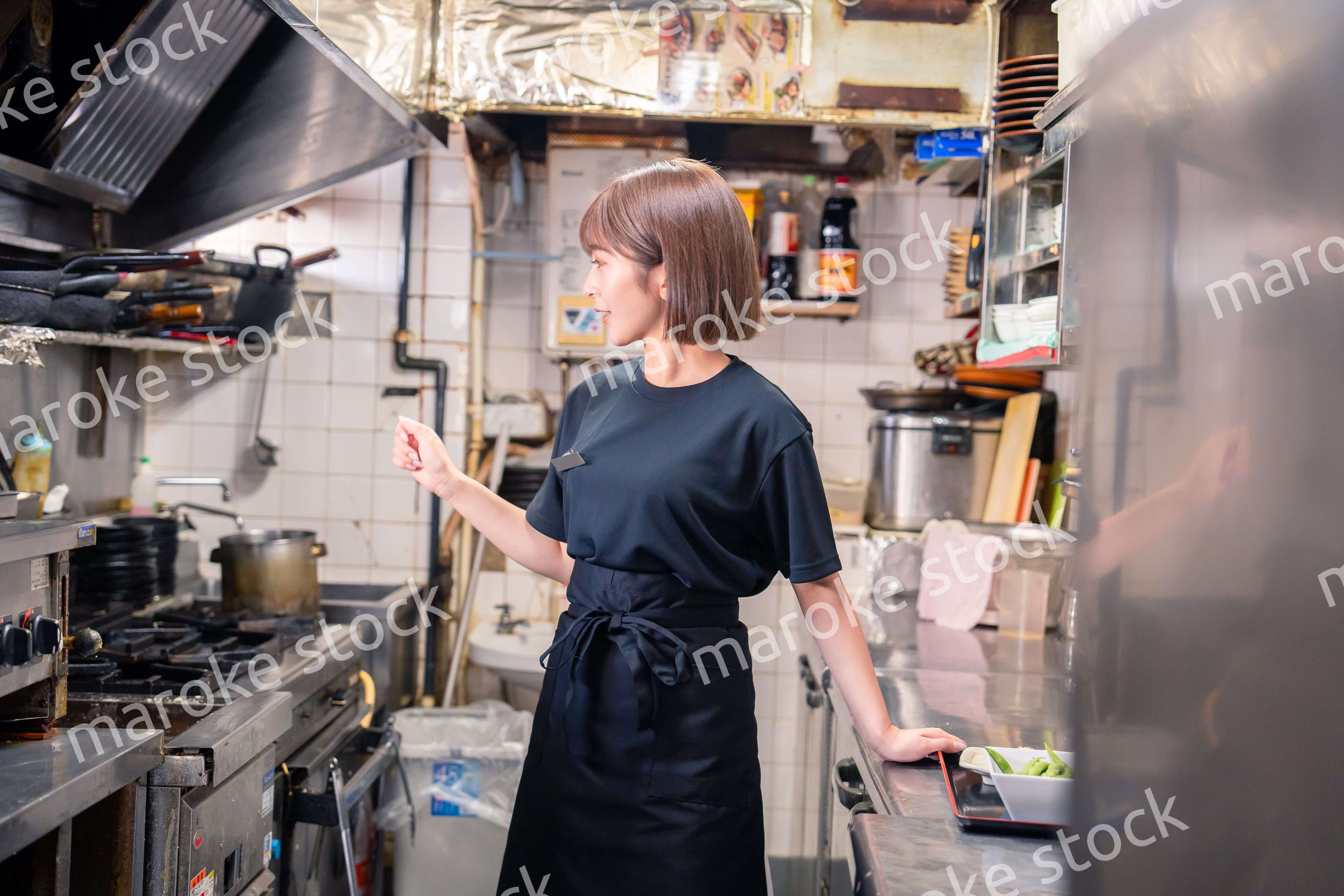 居酒屋の厨房で働くキッチンスタッフの女性