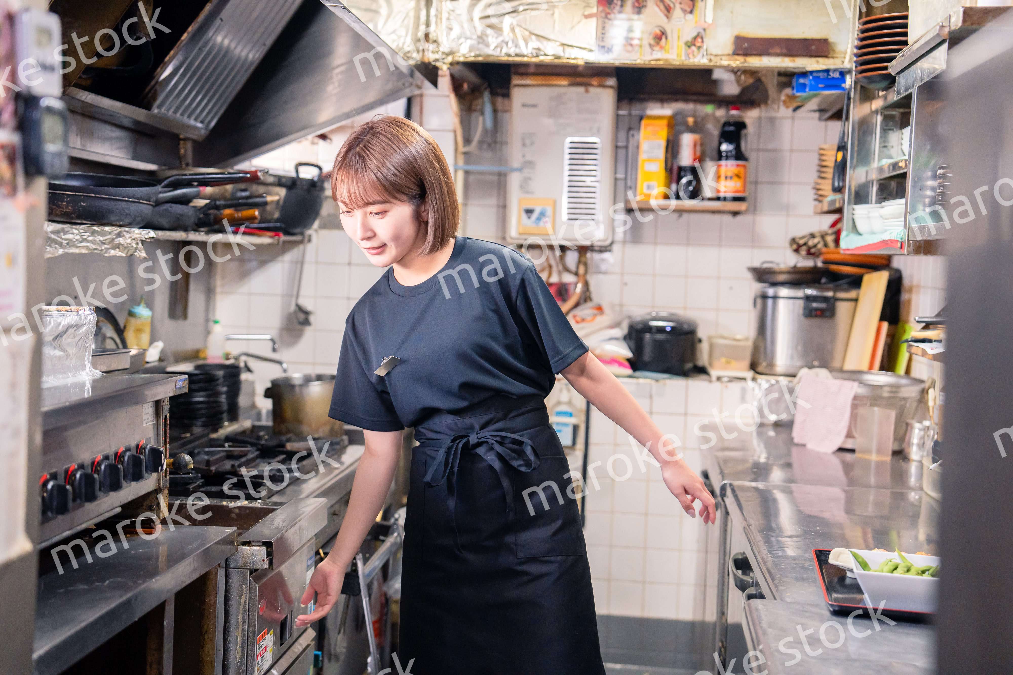 居酒屋の厨房で働くキッチンスタッフの女性