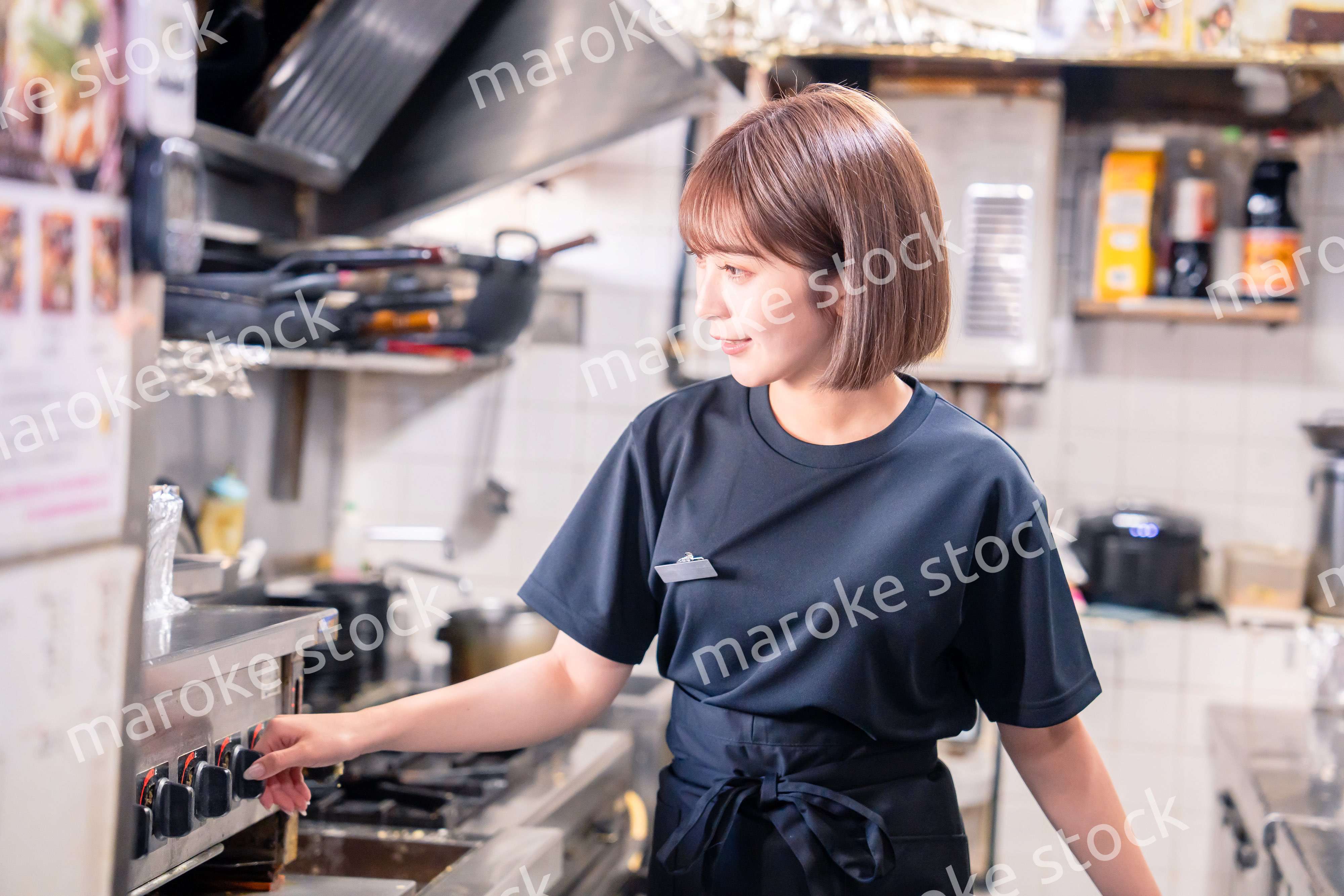居酒屋の厨房で働くキッチンスタッフの女性